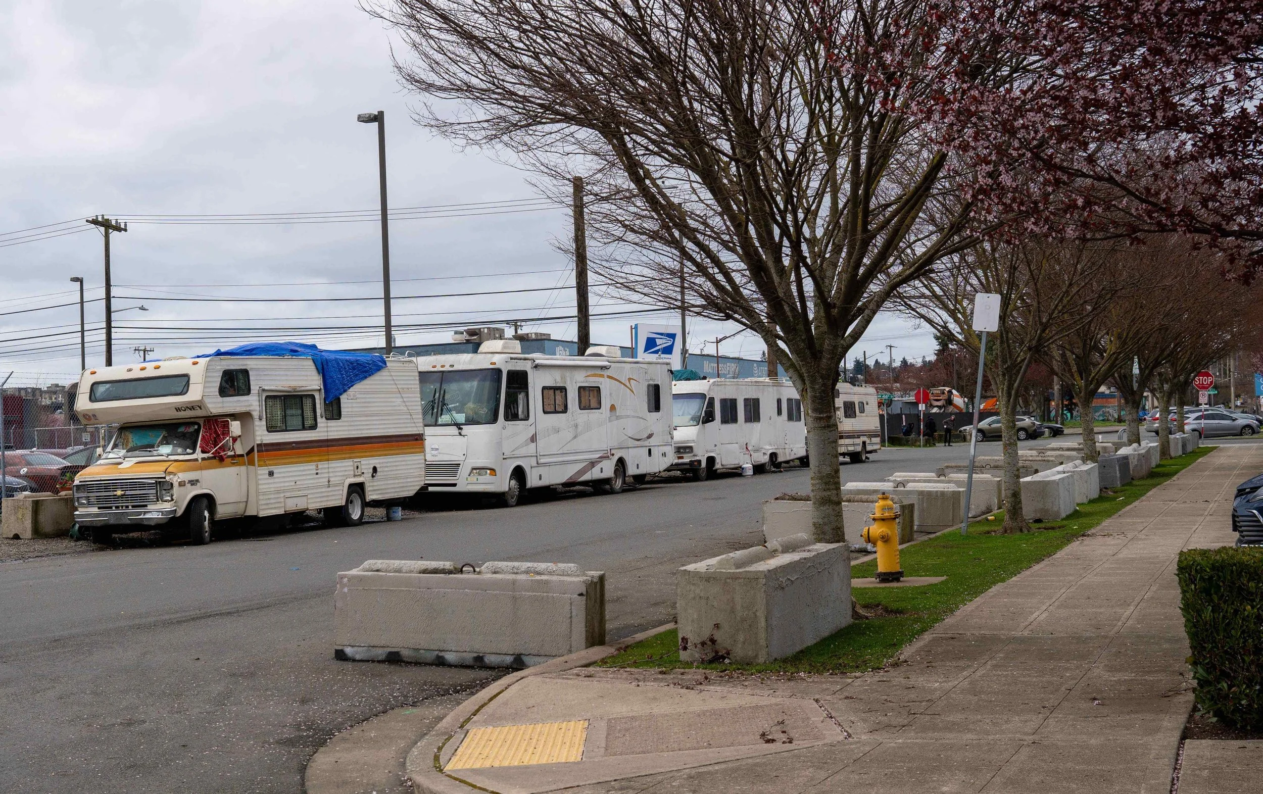 A long row of RVs and motorhomes used as residences parked along 17th Ave W near the Magnolia USPS annex in Seattle.