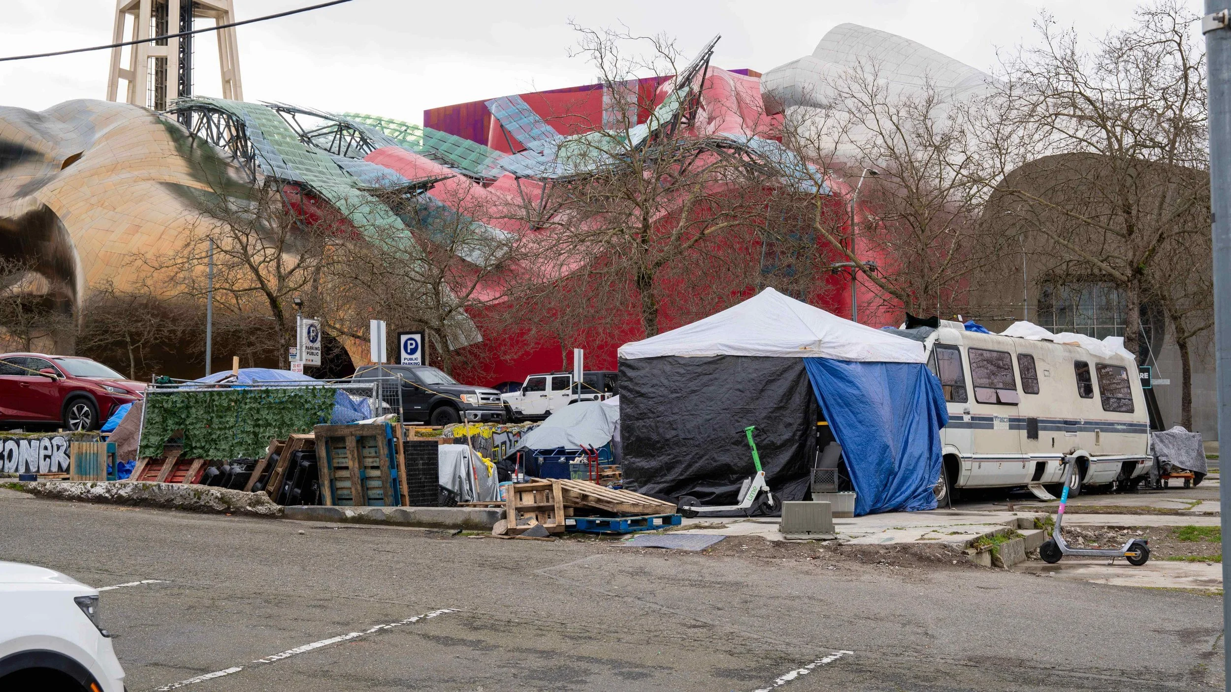 A makeshift homeless encampment with blue tarps positioned directly across from the Bill & Melinda Gates Foundation in Seattle.