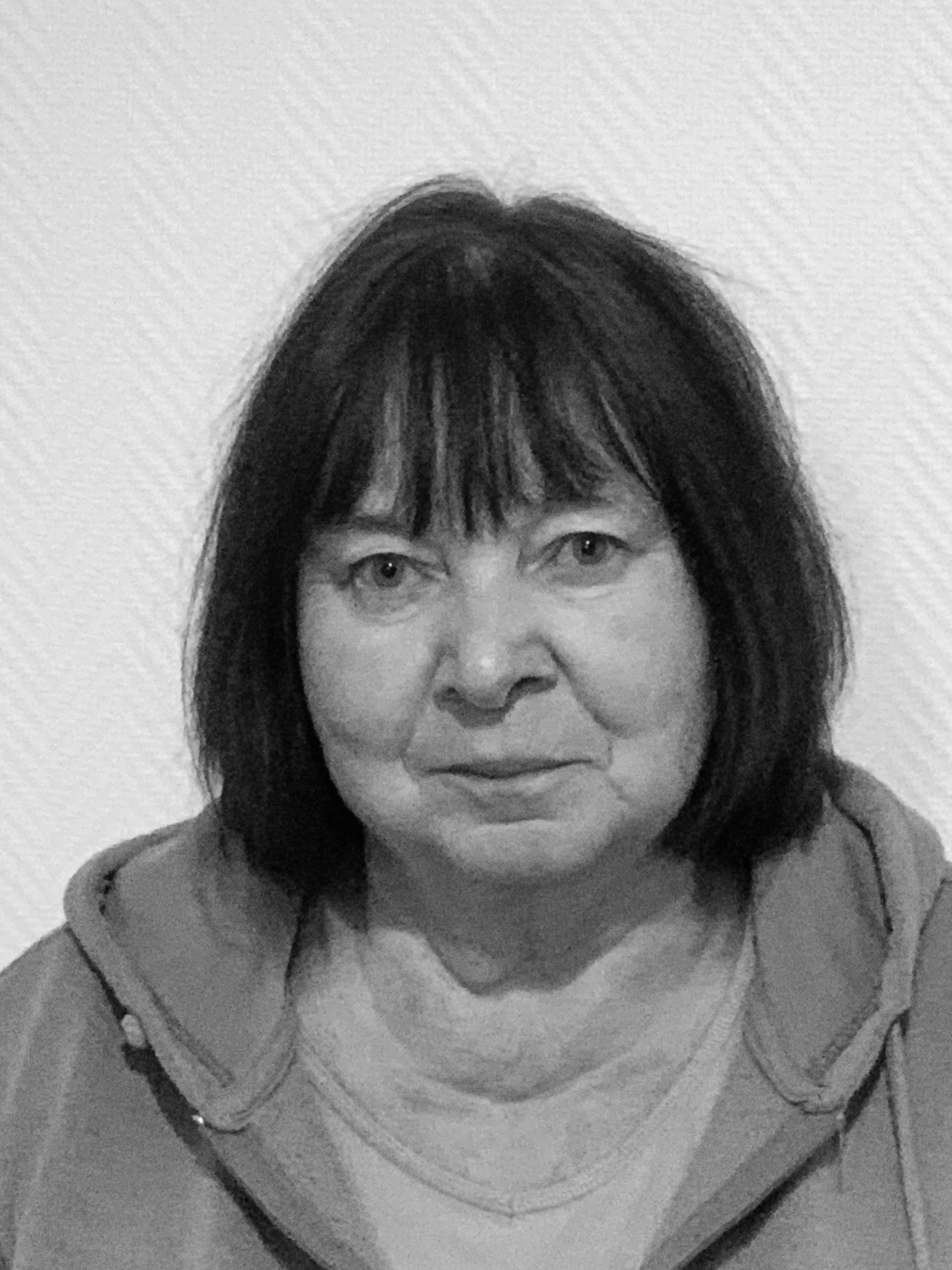 Portrait en noir et blanc d'une femme avec des cheveux bruns et un sourire neutre.