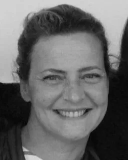 Portrait en noir et blanc d'une femme souriante avec cheveux ondulés