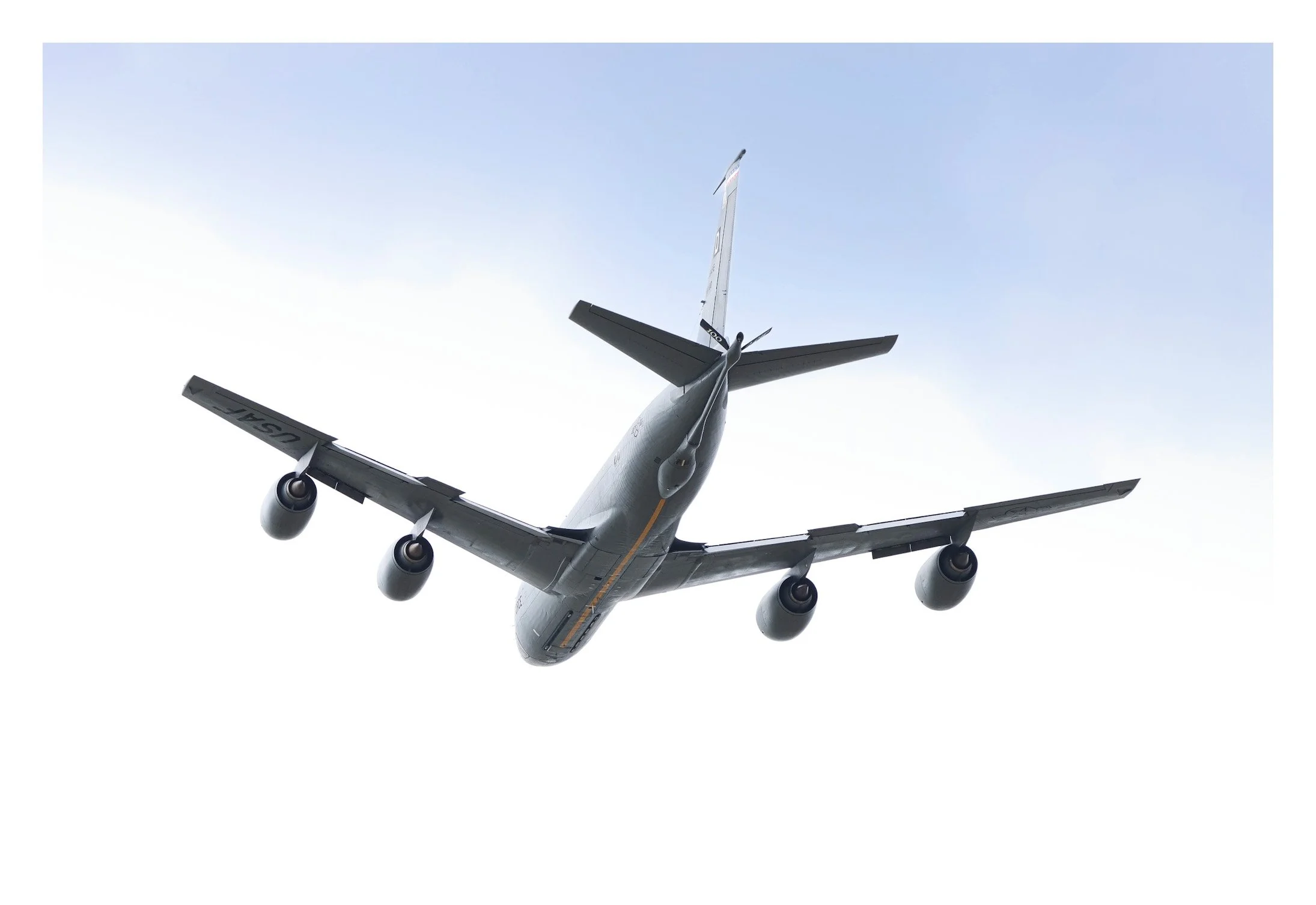 A commercial airplane seen from below flying in the sky with a clear, blue background.