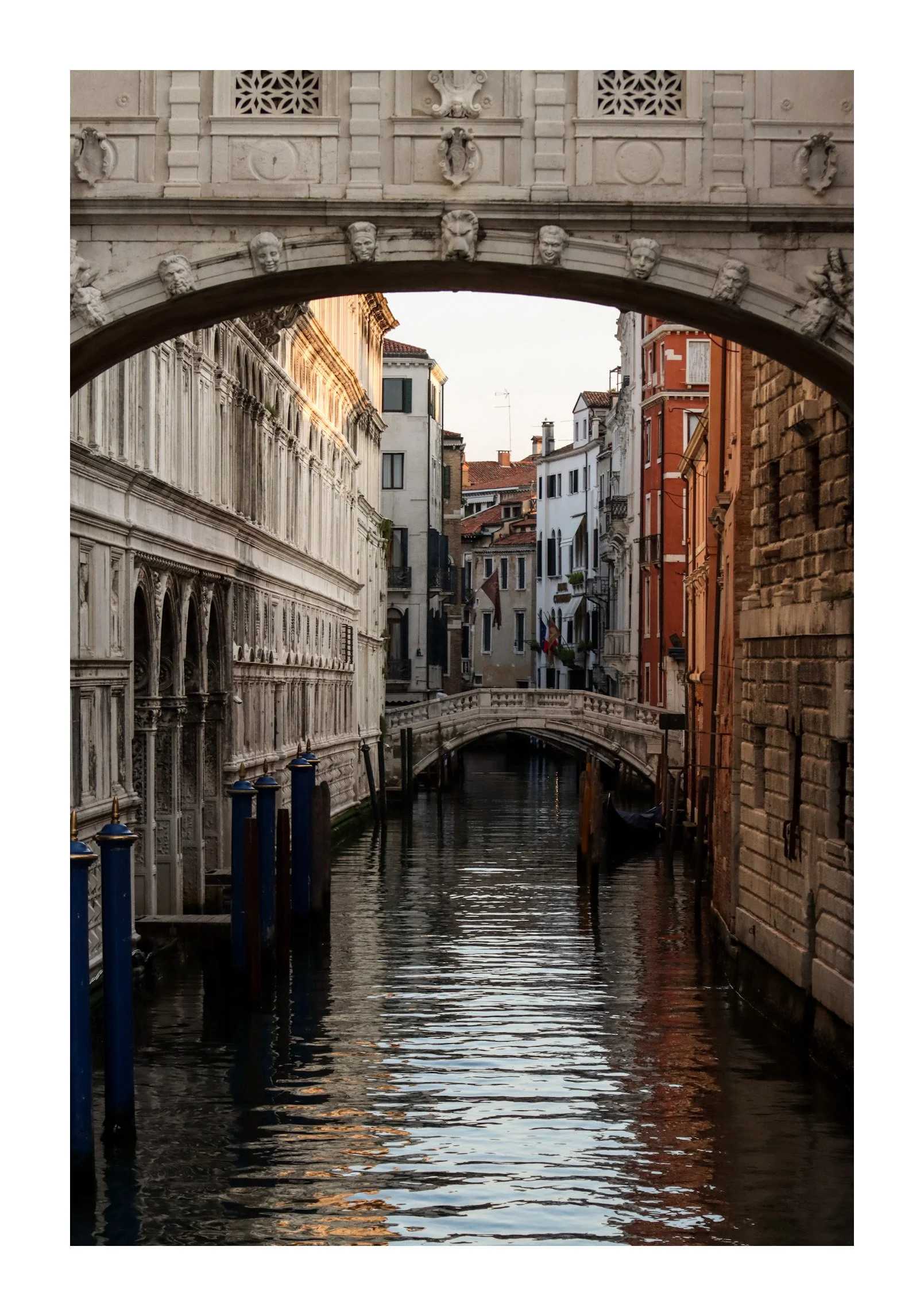 View of a narrow canal with small footbridges, flanked by historic buildings in Venice, Italy.