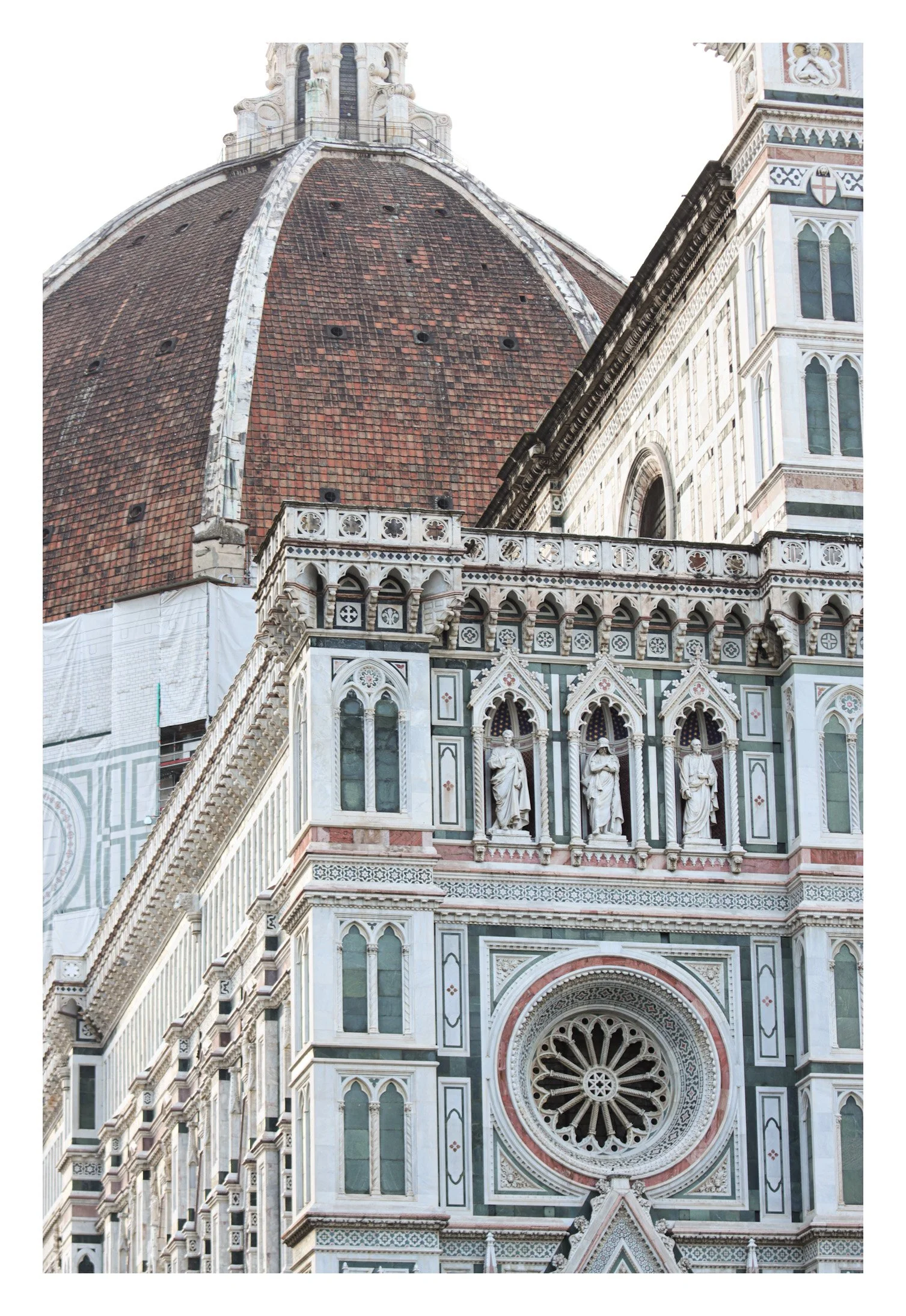 Close-up of the Florence Cathedral in Italy, showing detailed marble façade with statues and a large rose window.