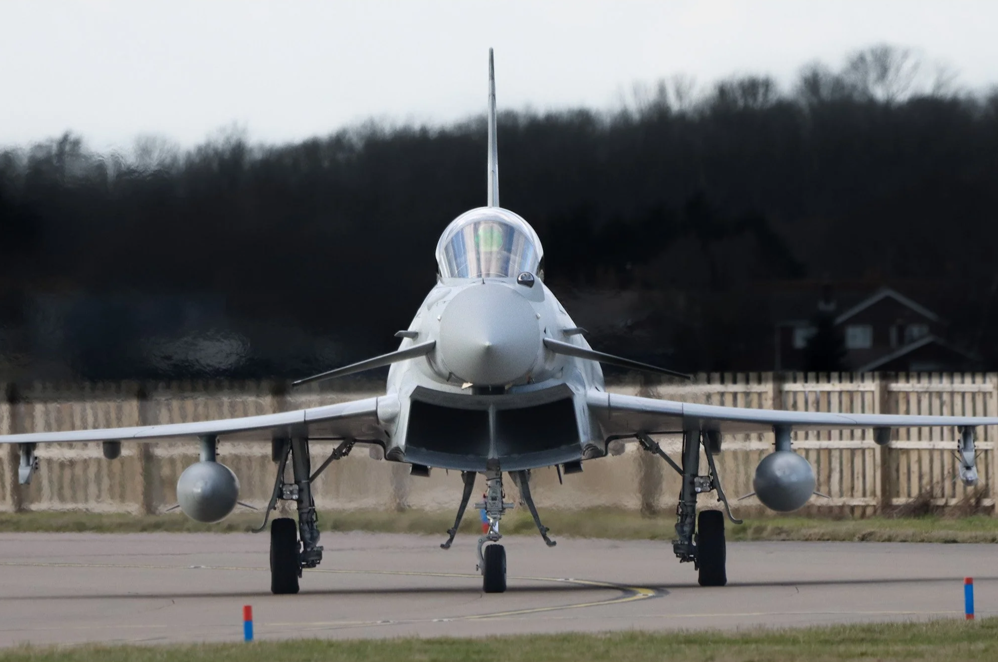 Front view of a fighter jet on the runway during daytime.