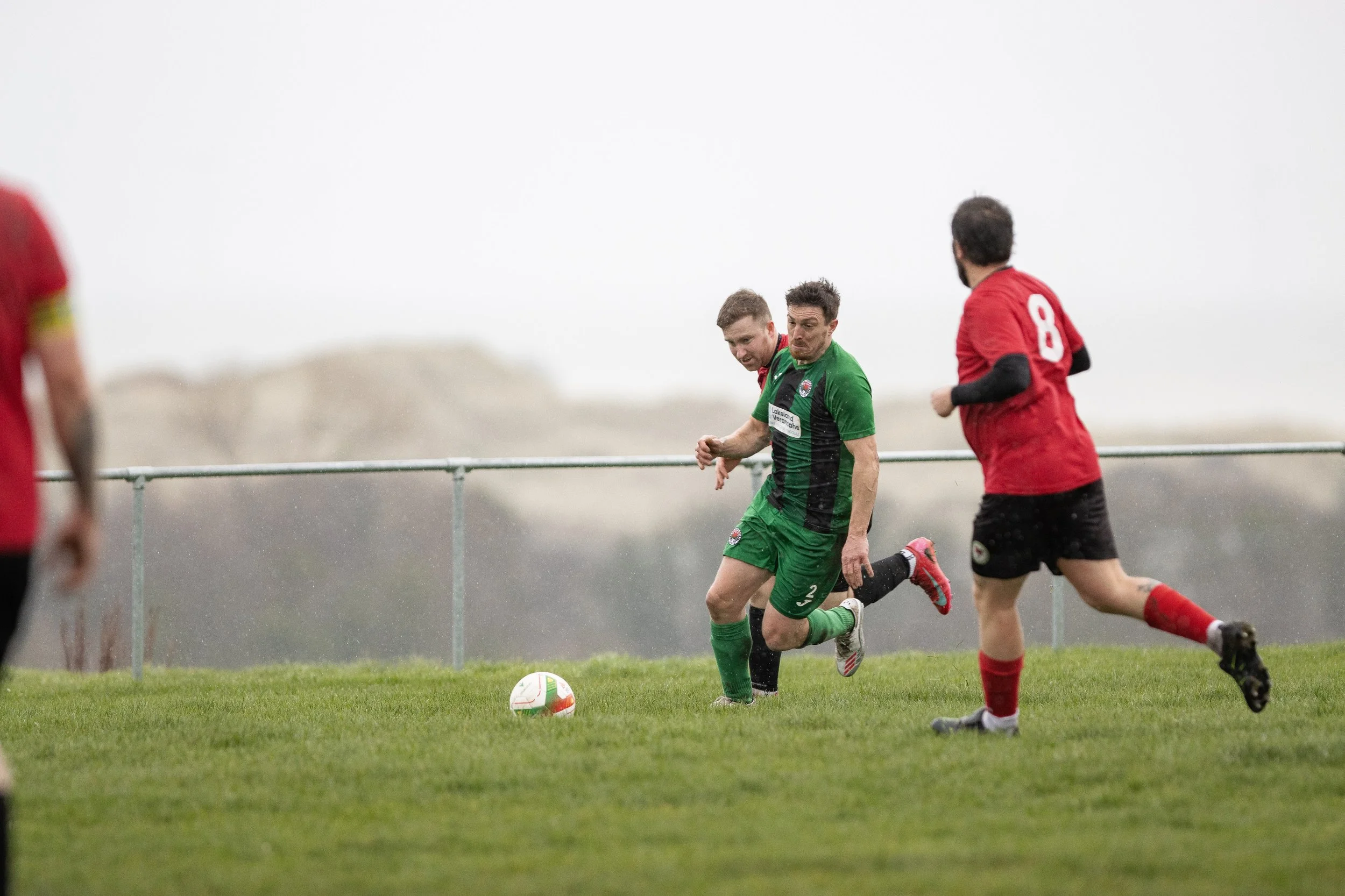 Soccer players competing for the ball during a match on a grassy field