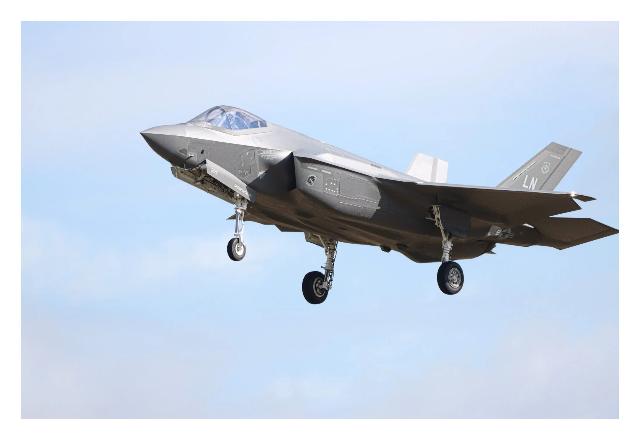 A fighter jet aircraft flying in clear blue sky.