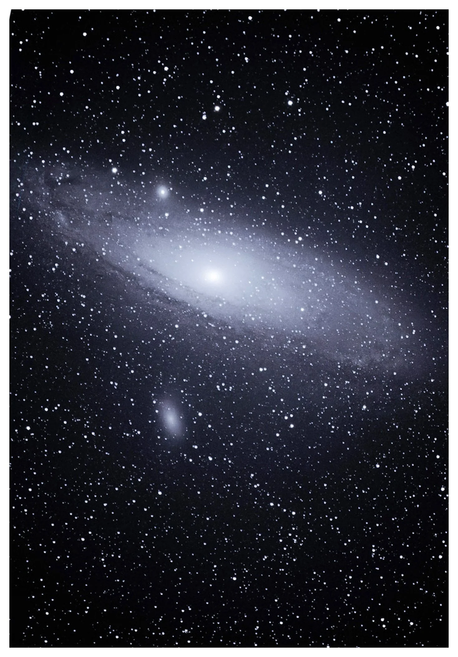 A photograph of a galaxy in deep space, featuring a bright, glowing center and countless stars scattered throughout the dark background.