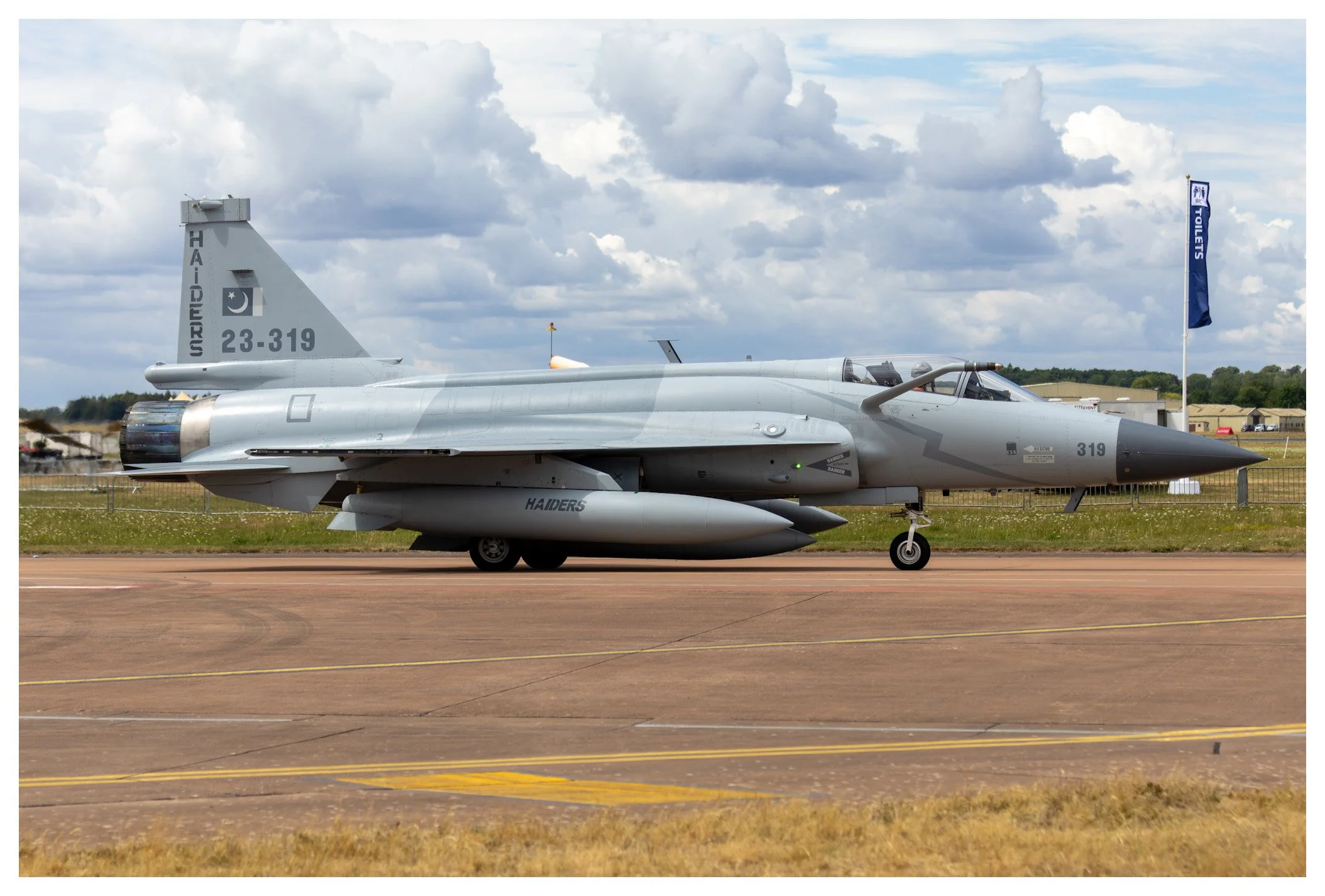 A military fighter jet aircraft parked on a runway.