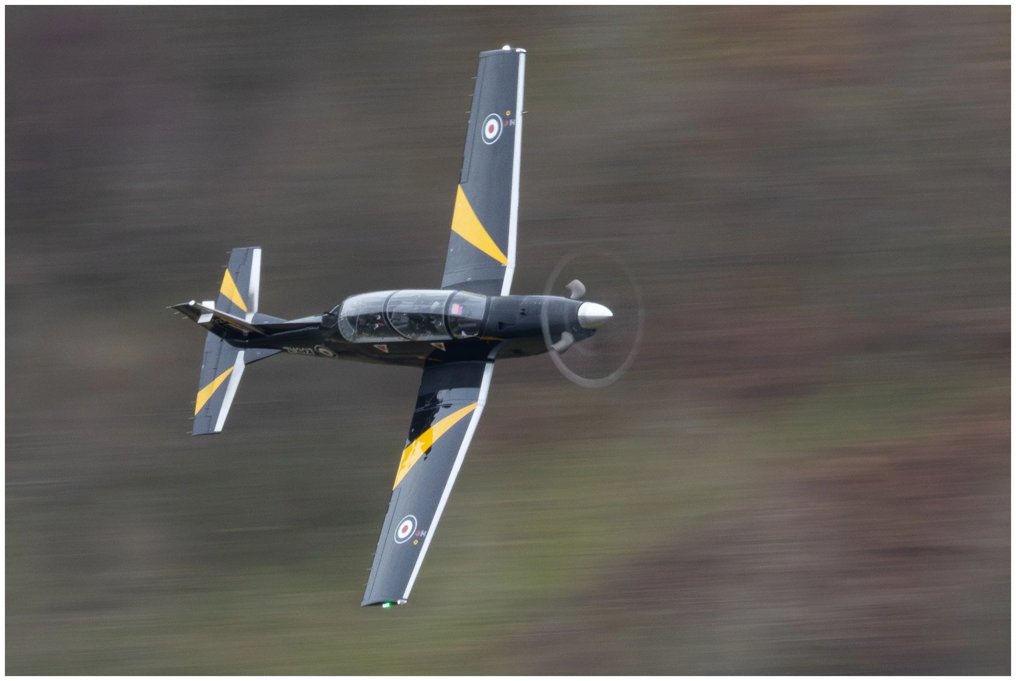A jet aircraft flying at high speed with a blurred background.