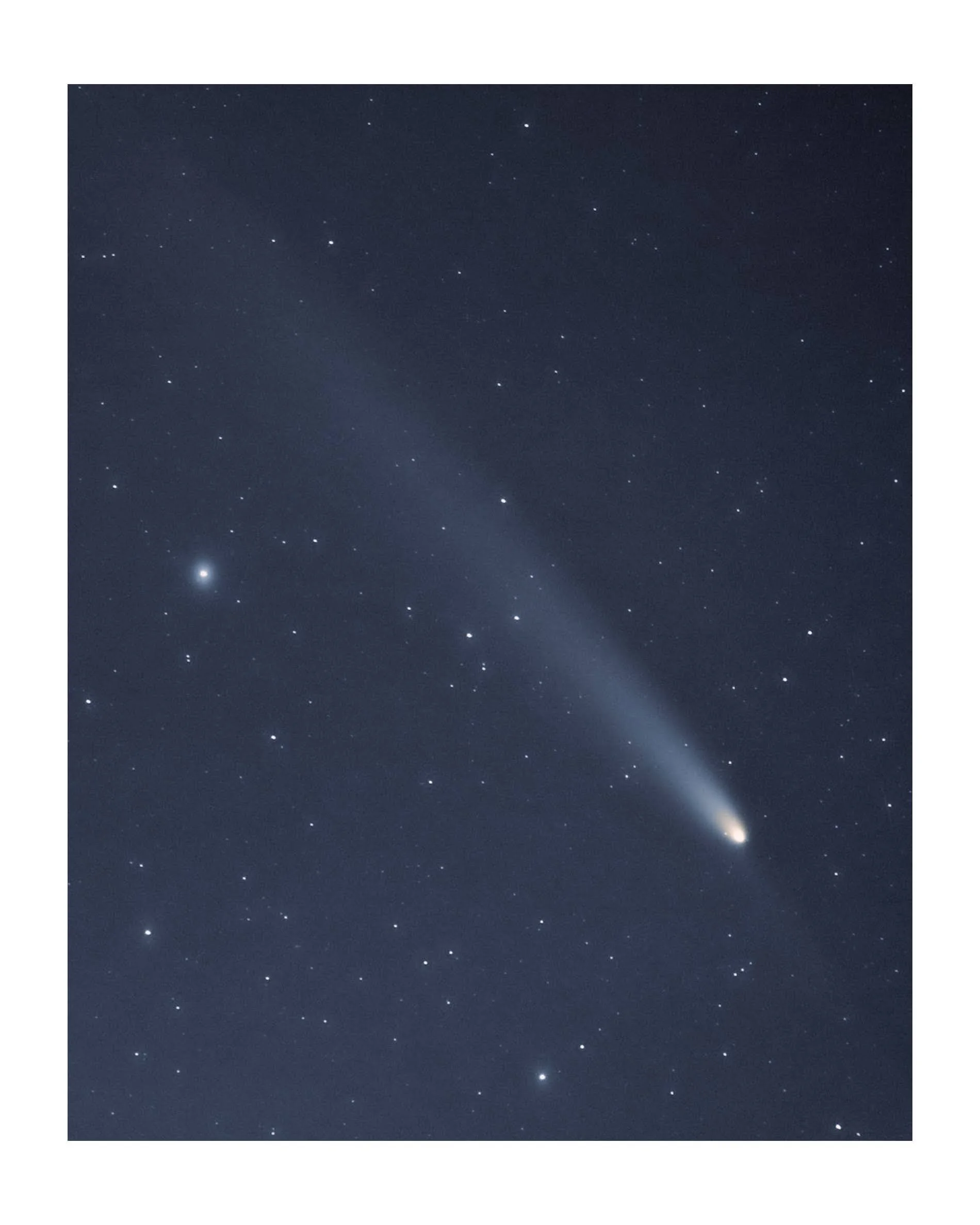 Night sky with a bright comet and stars.