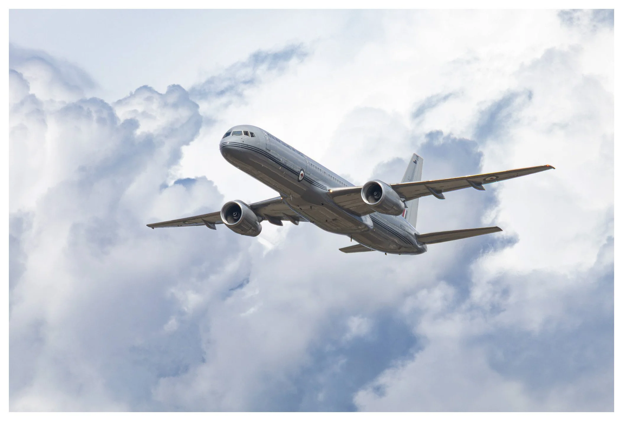 A commercial airplane flying through a partly cloudy sky.