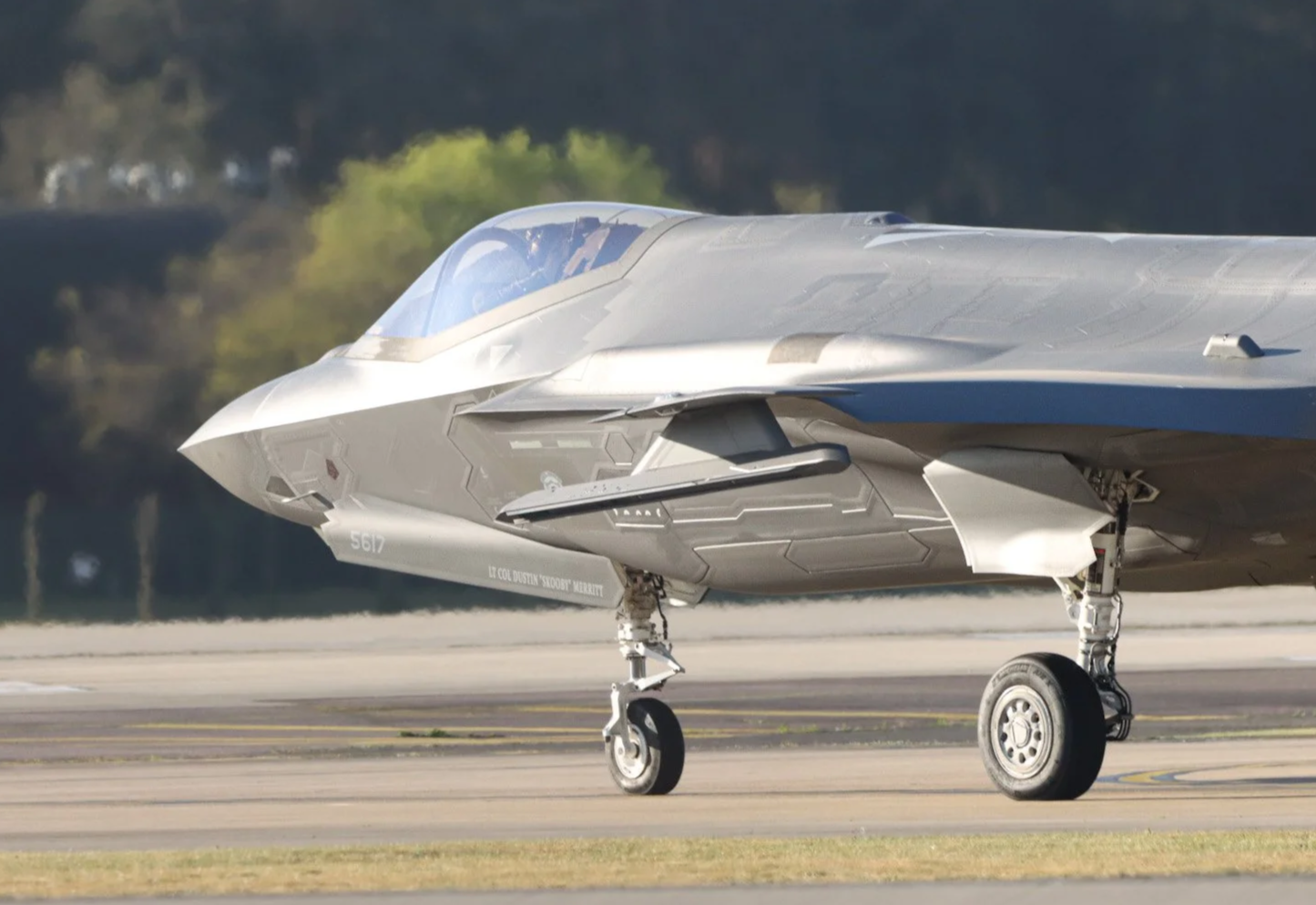 A modern fighter jet aircraft on the runway with landing gear down.