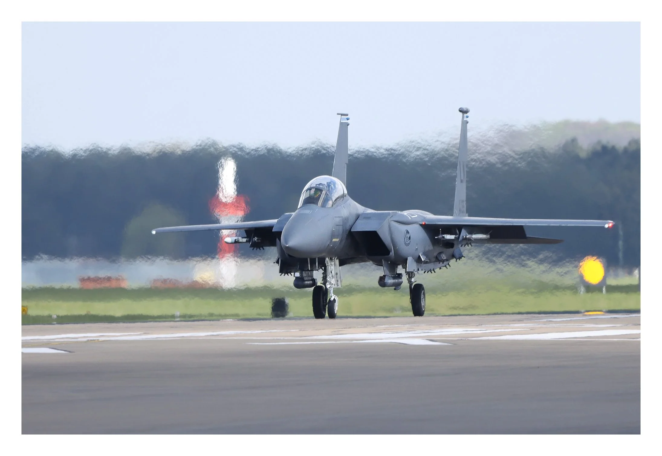 A fighter jet is taxiing on a runway at an airport.