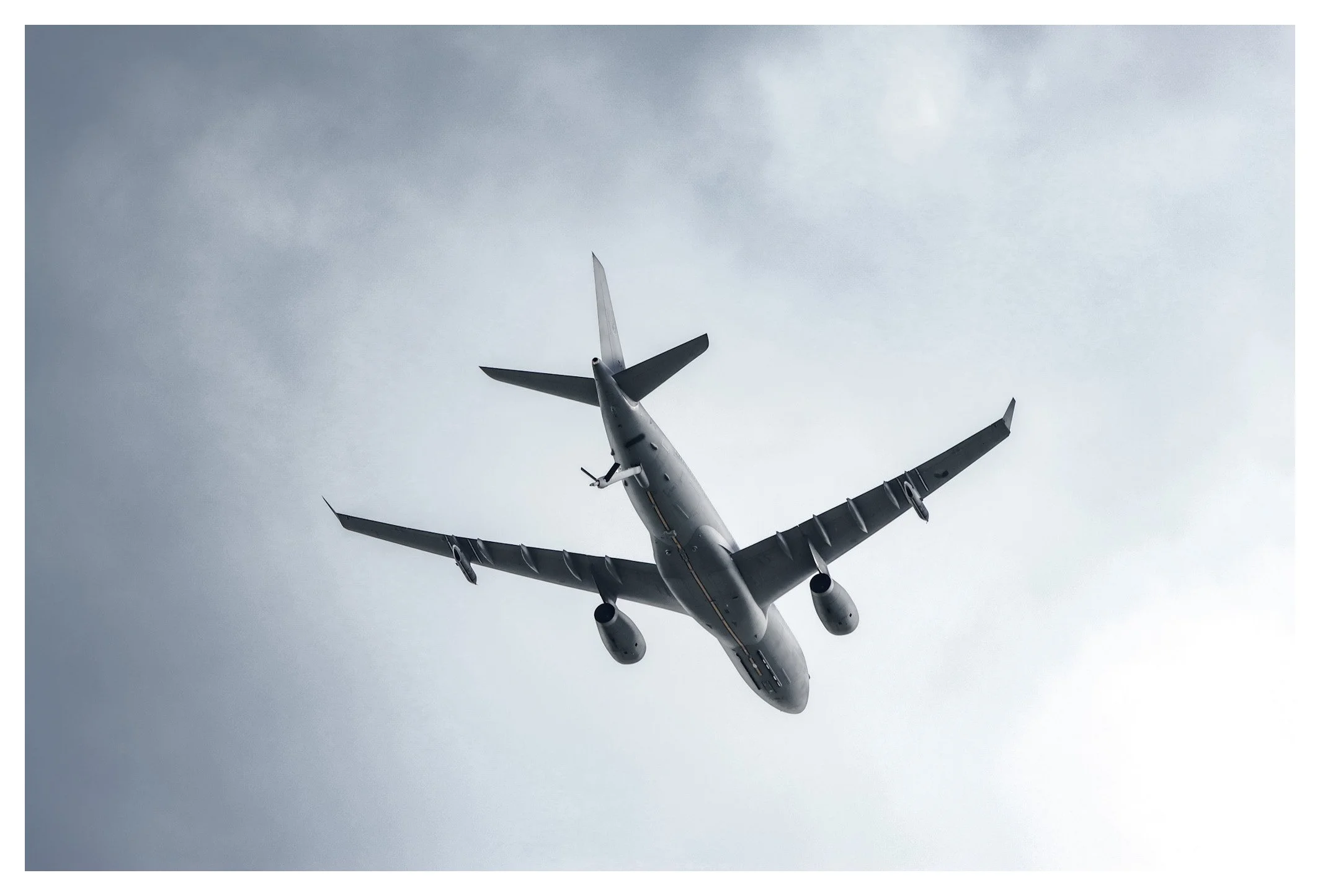 An airplane flying in the sky viewed from below.