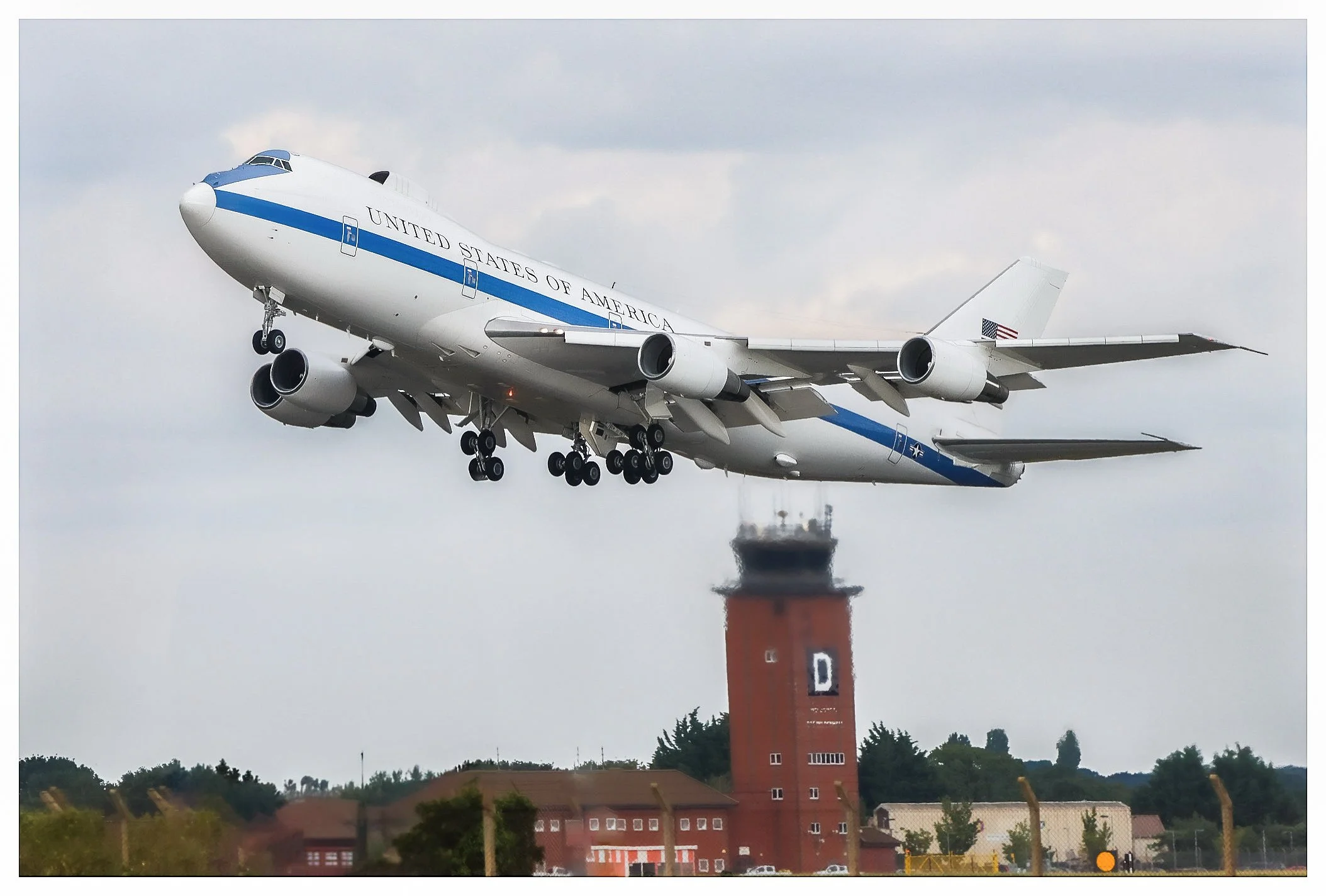 The Space Shuttle Atlantis taking off from Kennedy Space Center with cloudy sky background.