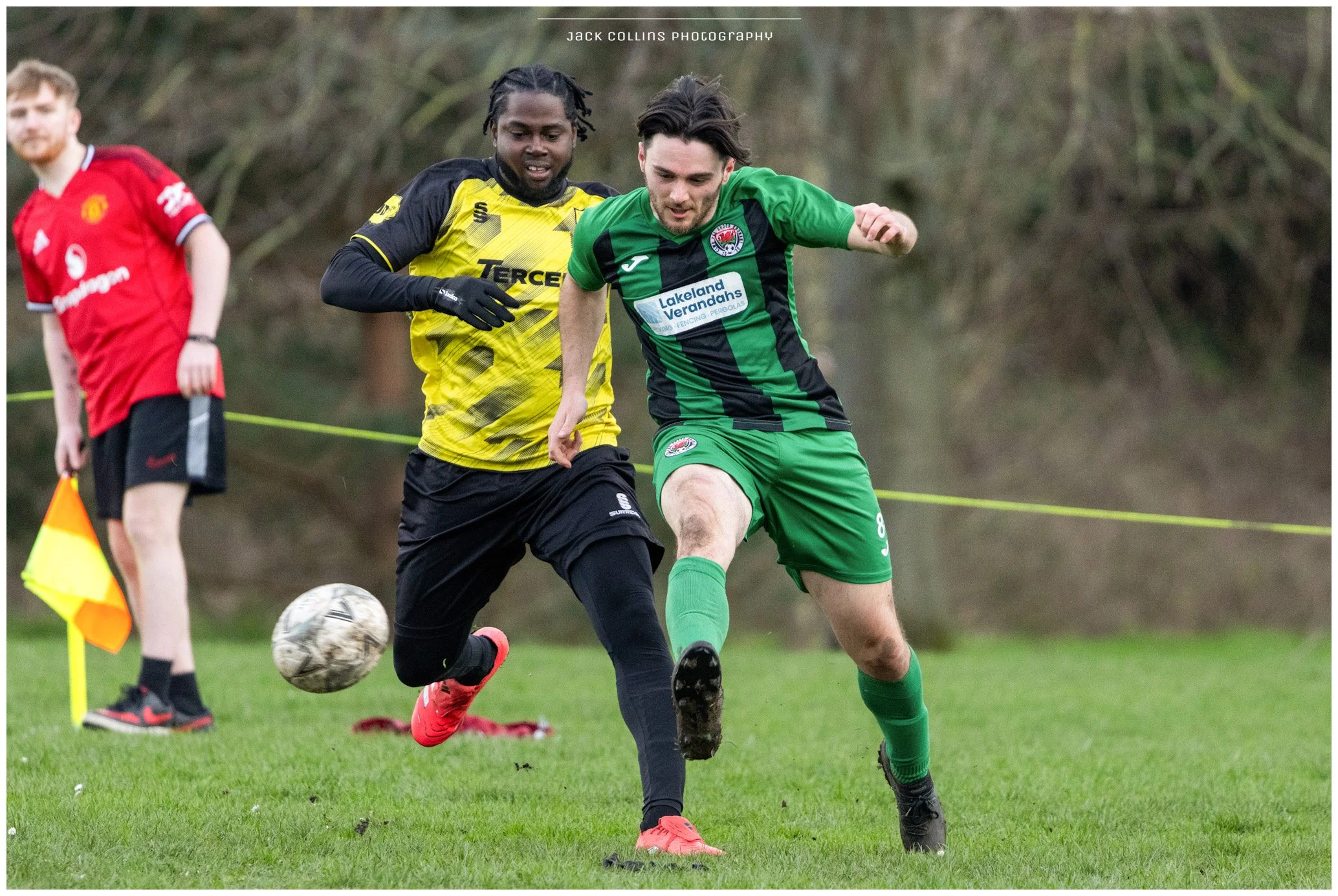 Back of a muddy soccer player in a green uniform with the number 19 on the back, during a game in rainy weather.