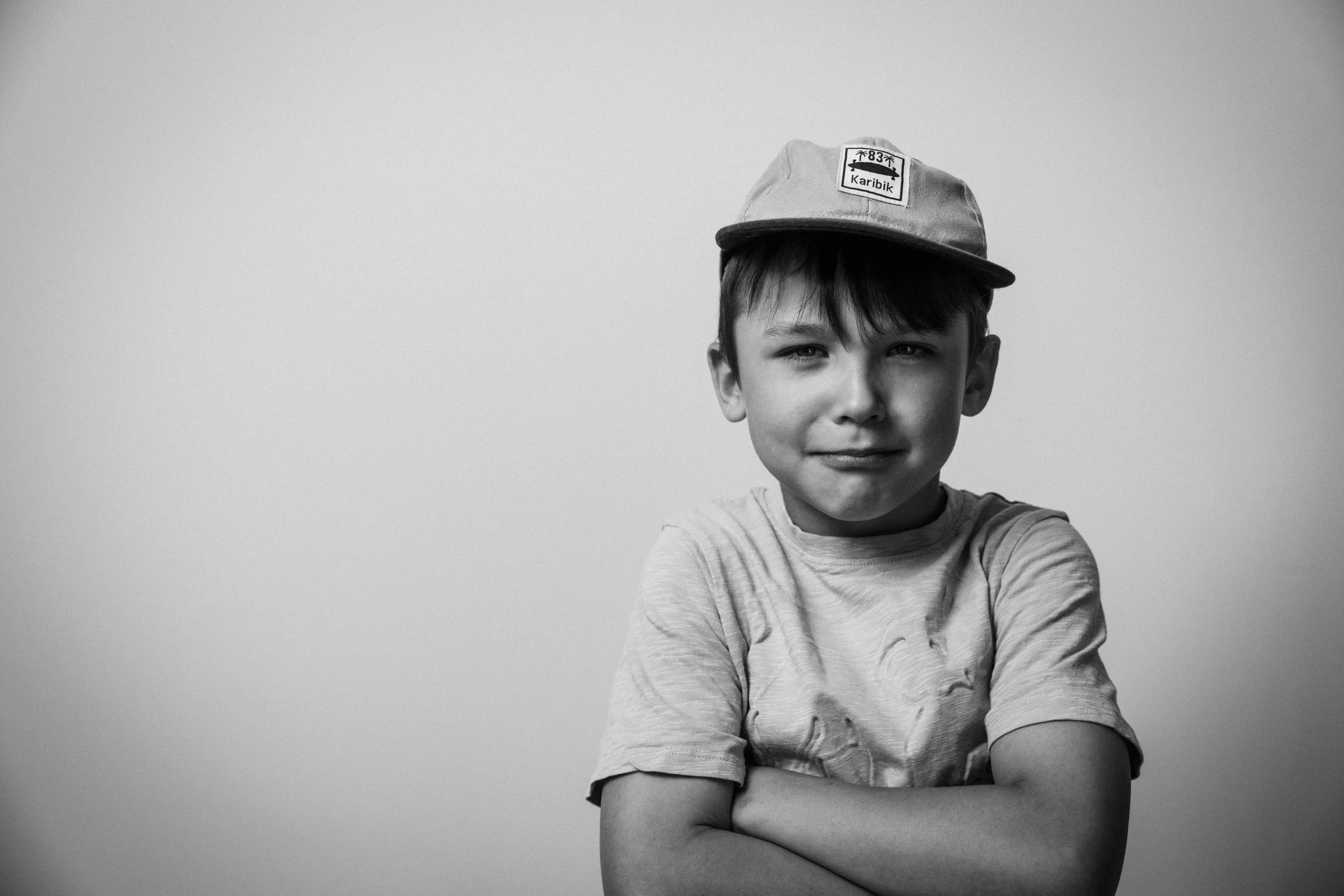 Jugendlicher Junge, lachend, trägt eine Mütze mit einem Patch, vor einem neutralgrauen Hintergrund. Erik von Buttlar  in  Das Wilde Weib – Das Musical · Birsteiner Festspiele 2027