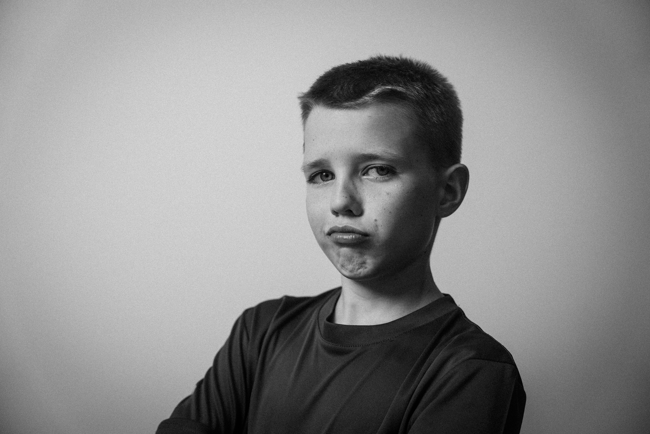 Schwarz-Weiß-Foto eines Jungen mit Kurzhaarfrisur, der eine dunkle Jacke trägt und nach links schaut. Leroy Brenkmann in  Das Wilde Weib – Das Musical · Birsteiner Festspiele 2027