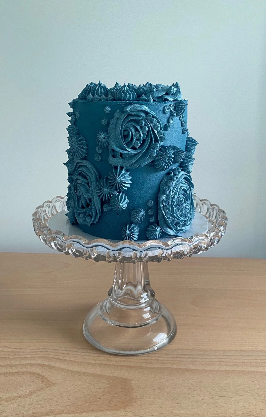 Small carrot cake with cream cheese filling, vanilla buttercream piped decorations coloured a deep blue for a 21st birthday.