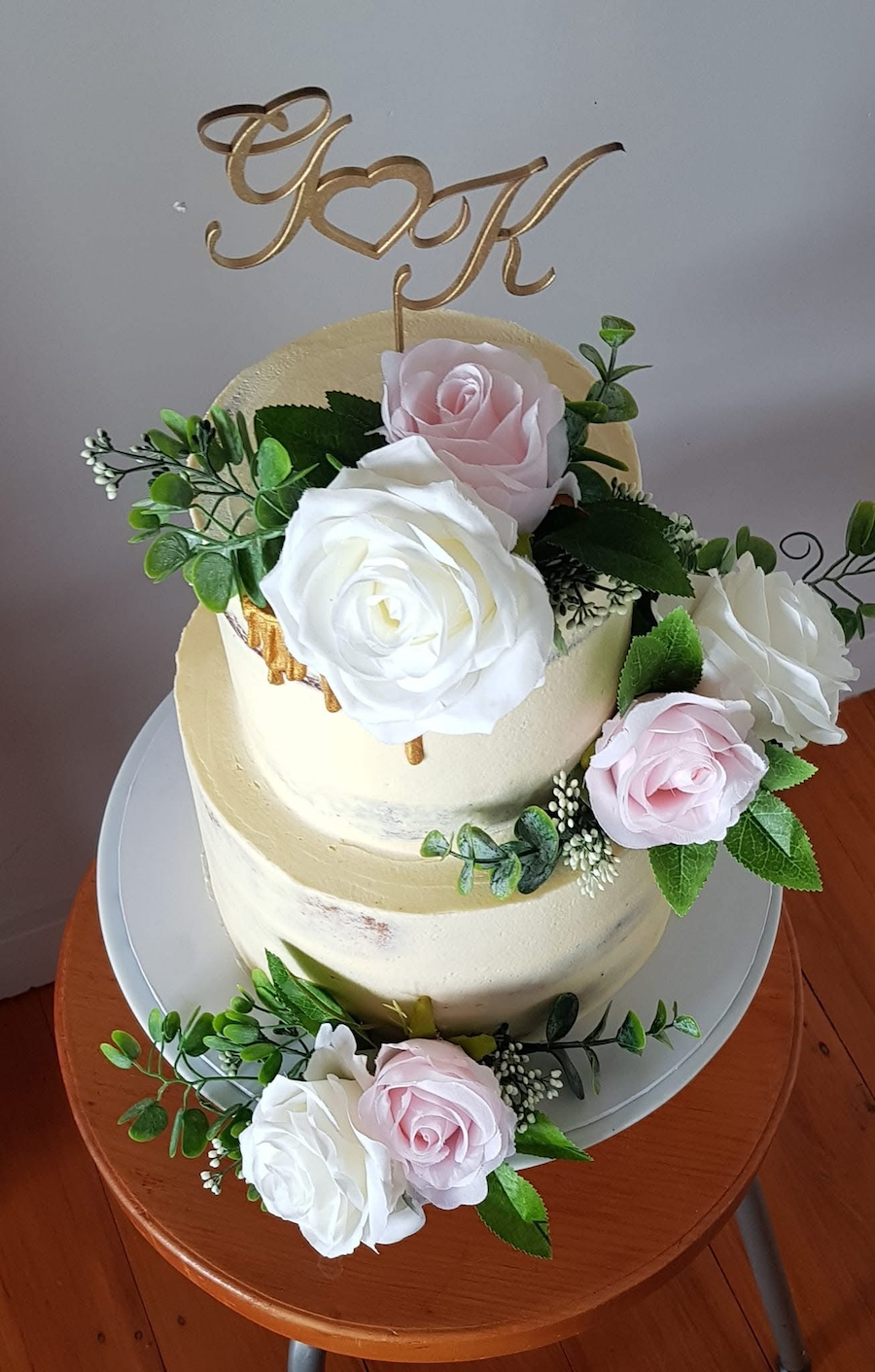 Two tier wedding cake; bottom tier banana cake with lemon curd filling; top tier white chocolate mud cake with white chocolate vanilla filling, icing was white chocolate vanilla buttercream and gold drip. Artificial flowers sourced and arranged by me