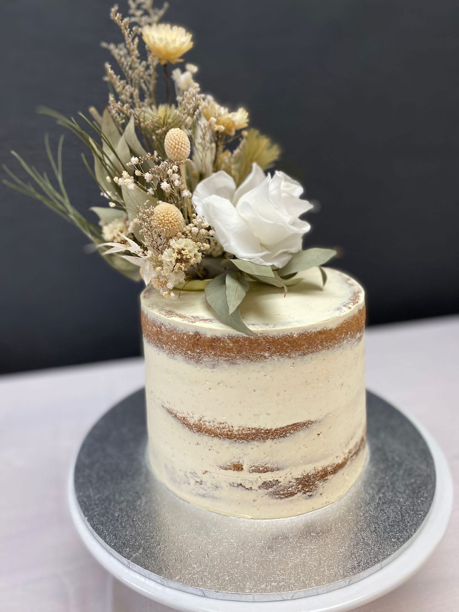 Semi naked wedding cake, layers of vanilla bean and coffee cake, filled and iced with vanilla italian buttercream. 