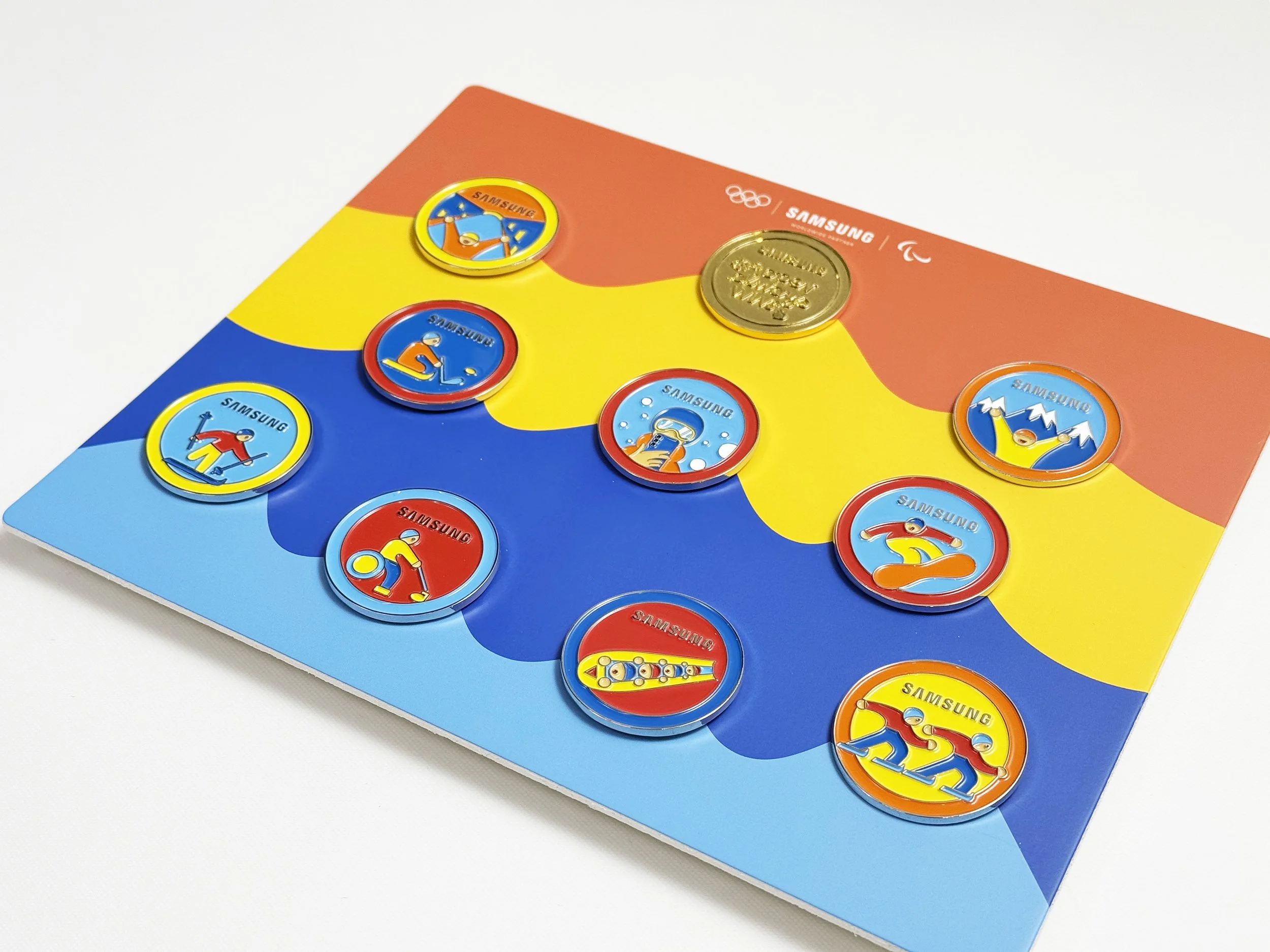 Close-up of the official Samsung VIP enamel pin collection for the 2026 Milan Cortina Olympics. 2026 밀라노 코르티나 올림픽 삼성전자 공식 VIP 핀 패키지. 글로벌 메가 이벤트 하이엔드 굿즈 양산 및 정밀 제작 실물.