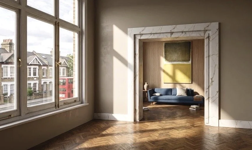 Living room with large window, view of houses and a red double-decker bus outside, doorway with white marble trim leading to another room with a blue sofa, side table, and artwork.