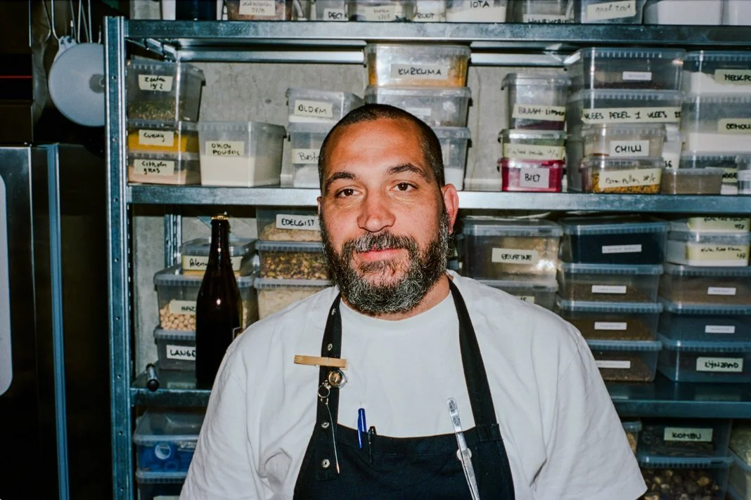 standing in a kitchen storage area lined with labelled ingredient containers