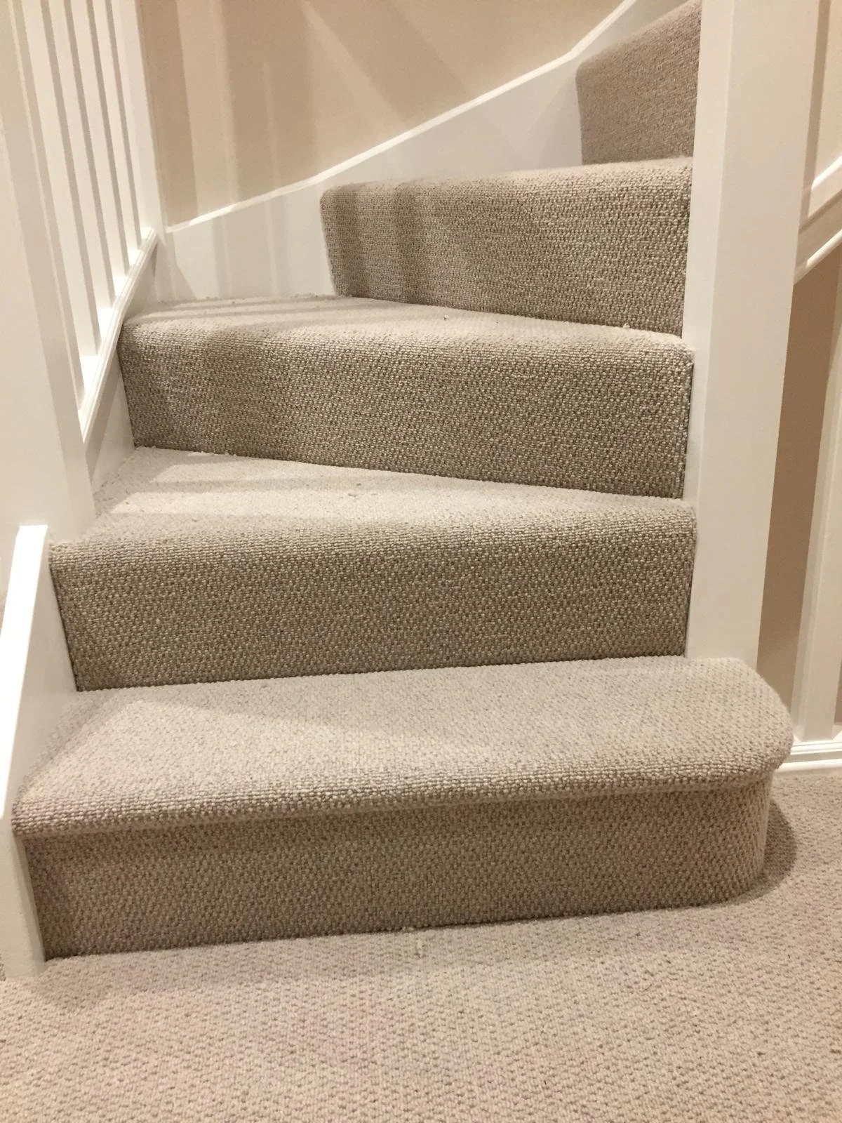 staircase with winders and bullnose carpeted with a natural wool loop pile carpet 