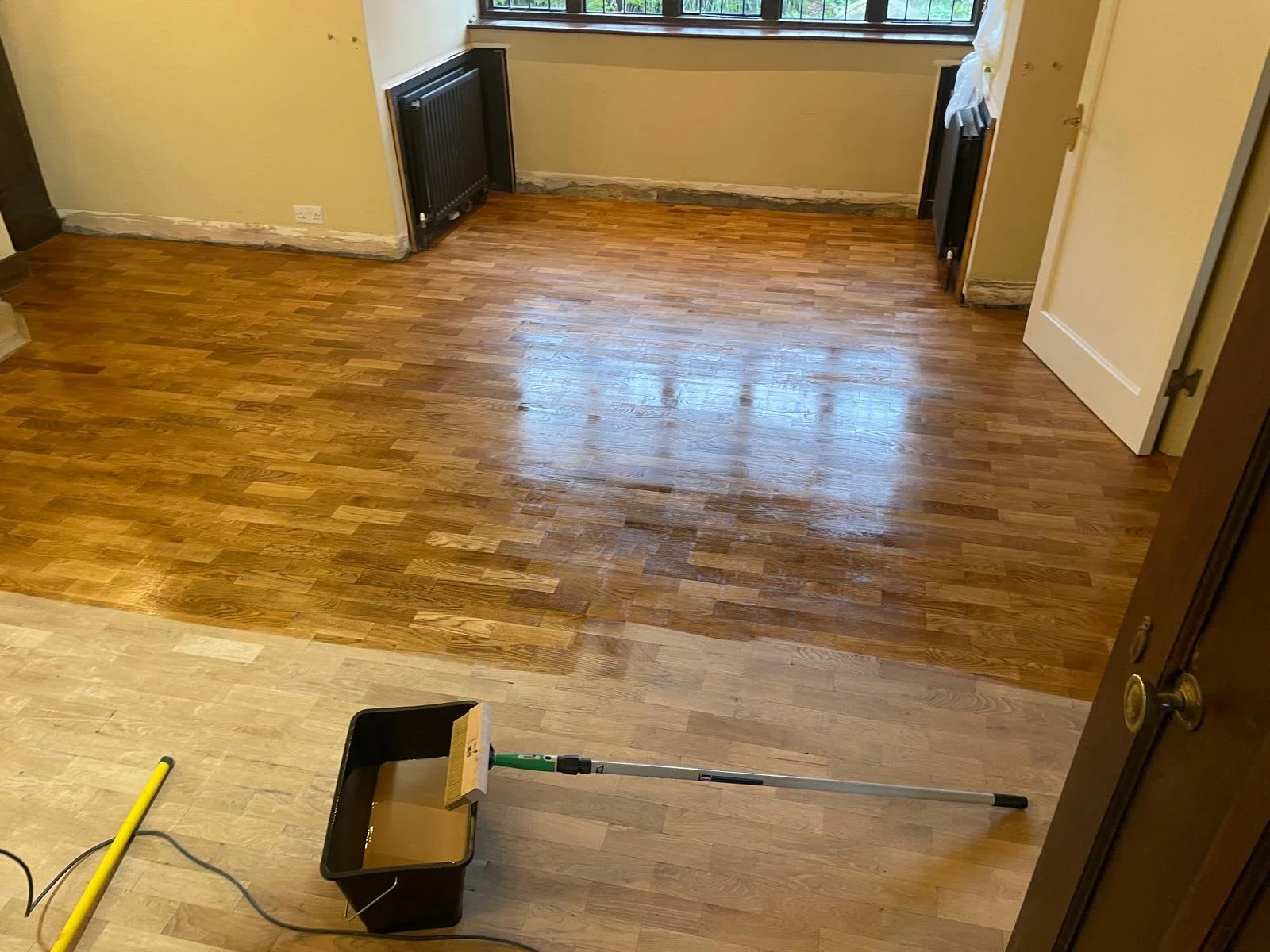 Room with a hardwood floor in the process of being cleaned or refinished.