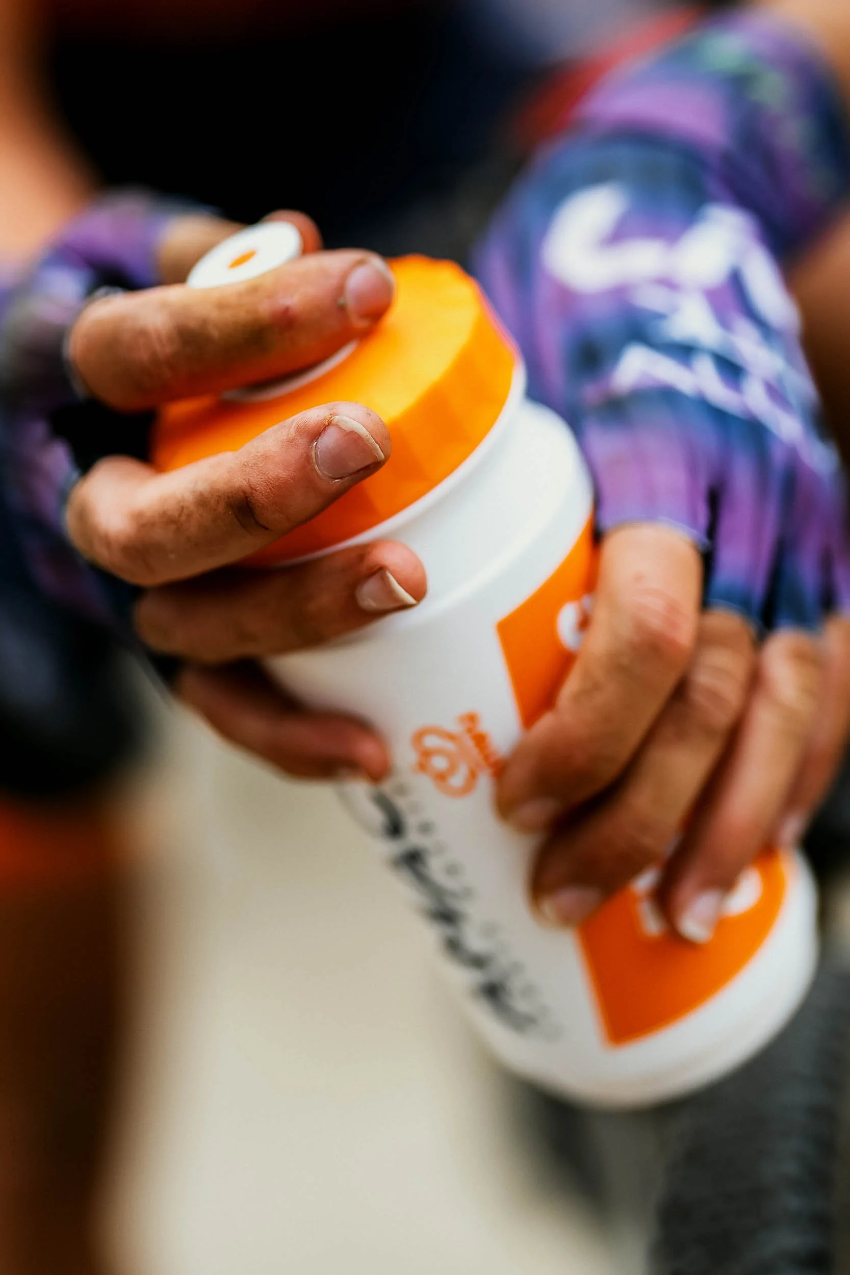 A person holding a McDonald's soft serve ice cream cone with orange and white coloring, with a visible McDonald's logo on the cup.
