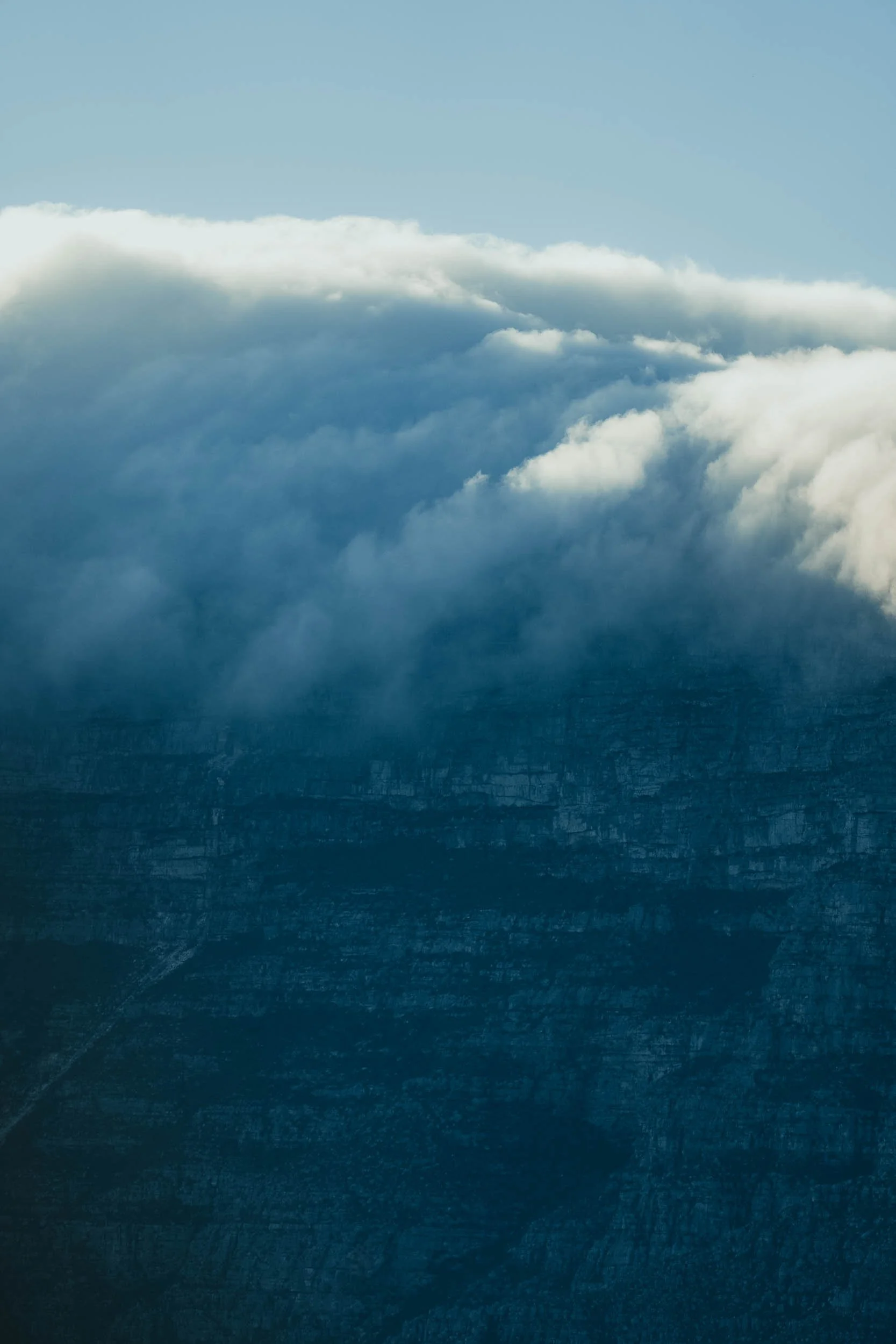 Aerial view of clouds and mountain landscape from above.