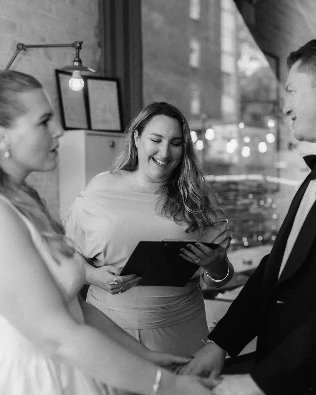 Smiling celebrant officiates wedding of happy couple