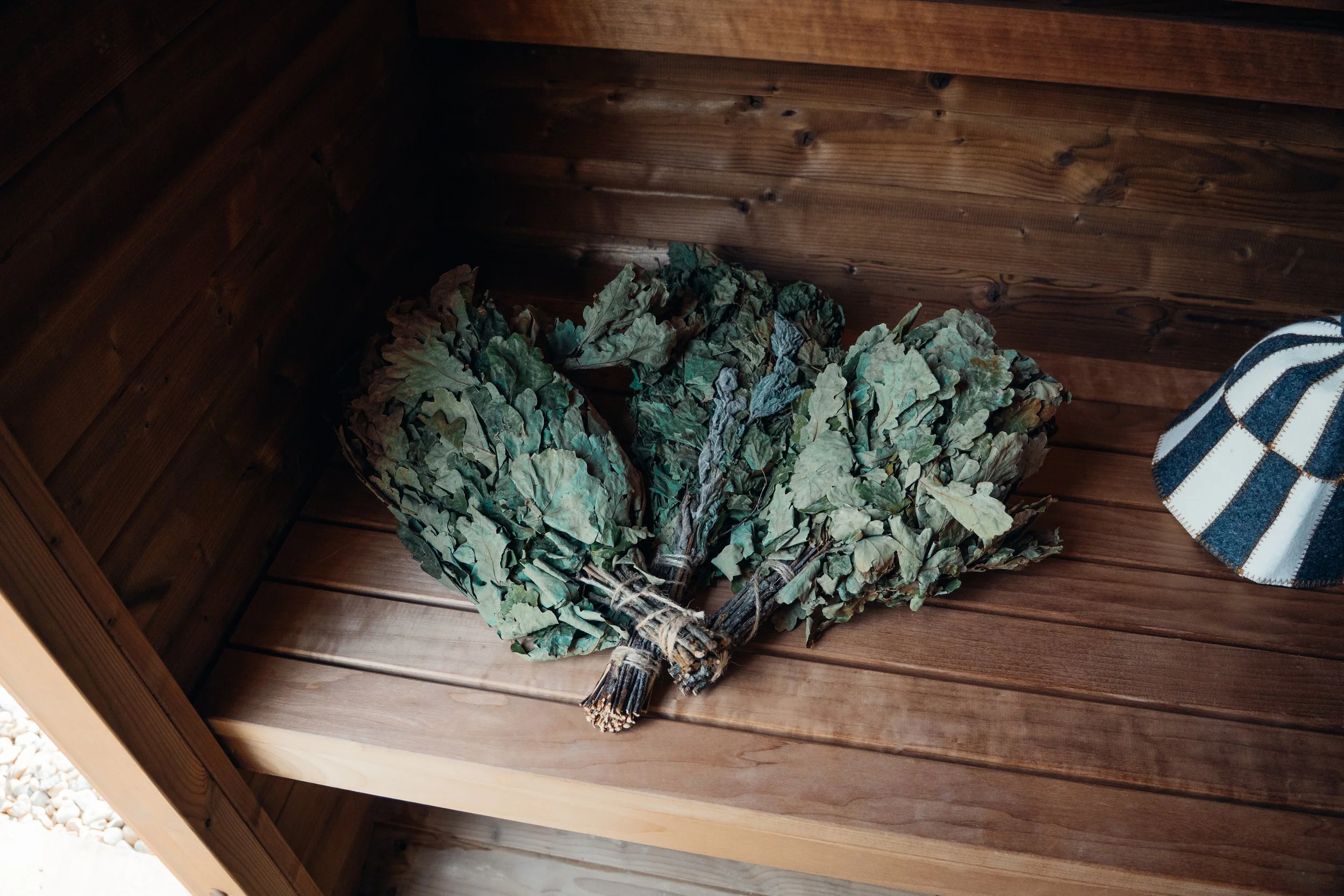 Bundles of dried sage leaves tied with twine inside wooden cabinet.