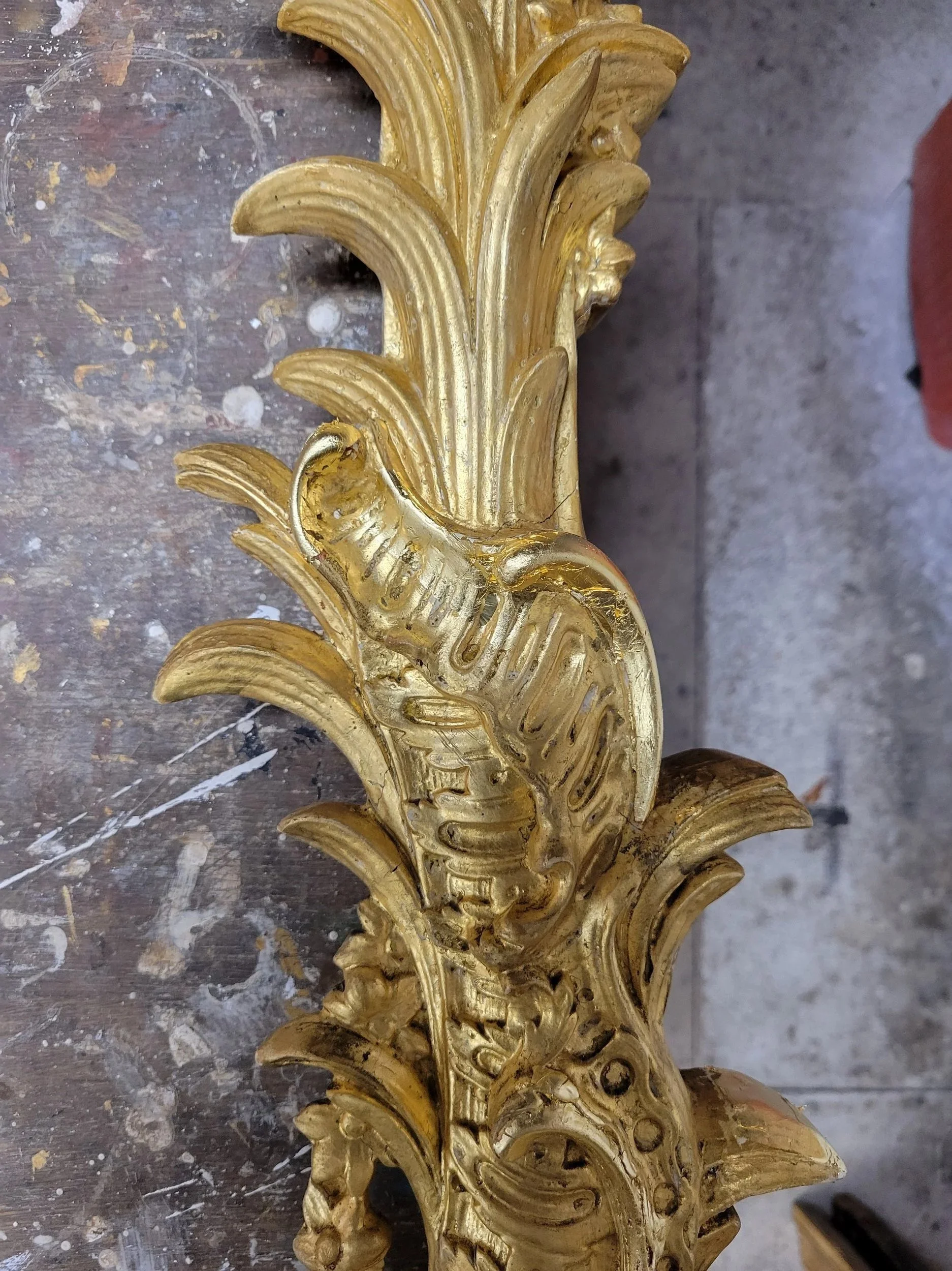 Ornement en bois ou en plâtre doré, sculpté avec des motifs de feuilles et de volutes, probablement une partie d'un mobilier ancien ou d'une décoration murale