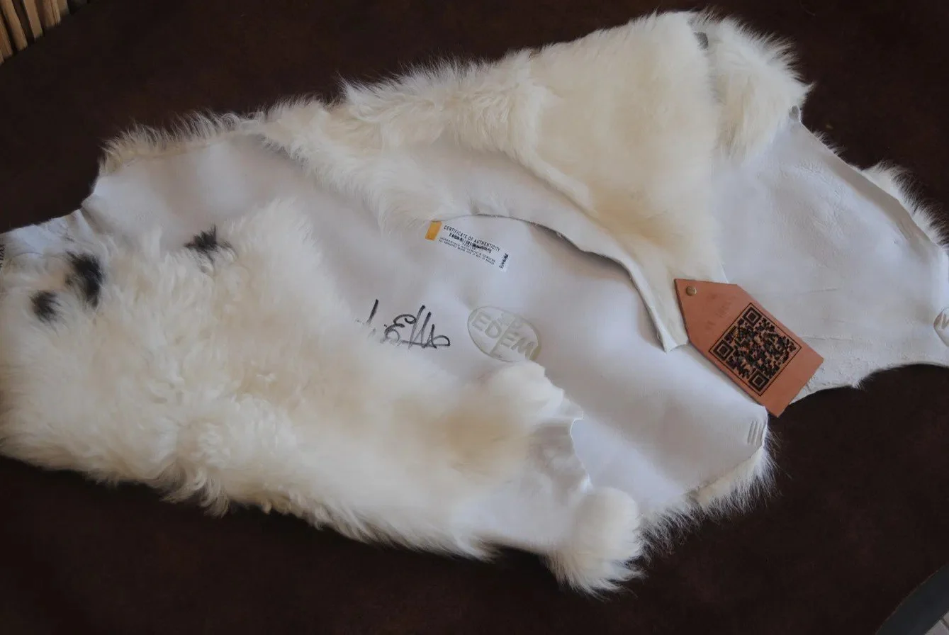 Vello ovino d'eccellenza Sa Peddi Sarda™ con firma autografa di Tuveri Edmondo, ologramma Void e cartellino in cuoio con QR code per la EDEM PEL SRL.