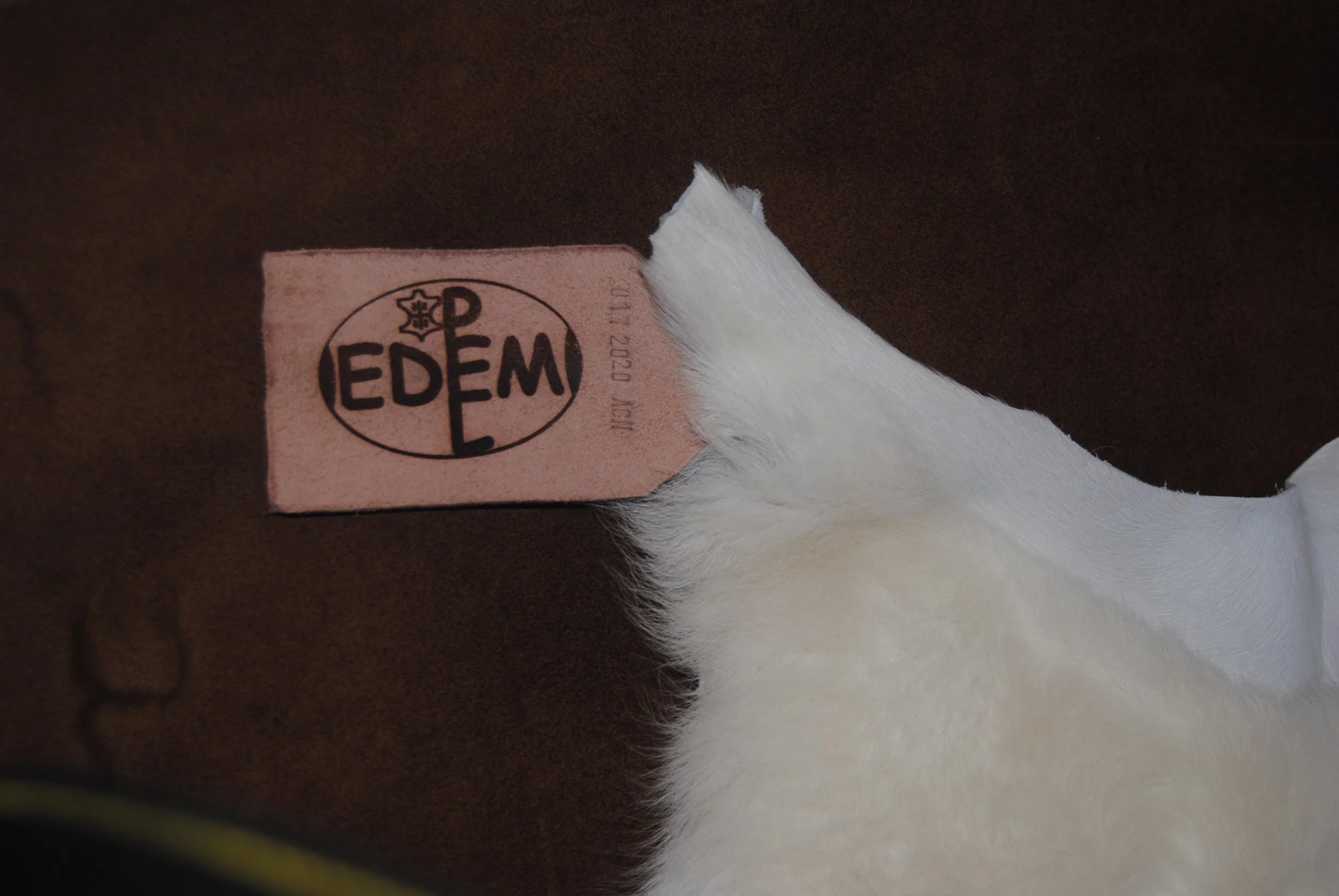 Detail of the EDEM/PEL SRL hot branding on premium Sardinian sheepskin, linked to the historical heritage of the Carta de Logu. Exclusive work by Tuveri Edmondo for the Sa Peddi Sarda™ Project.
