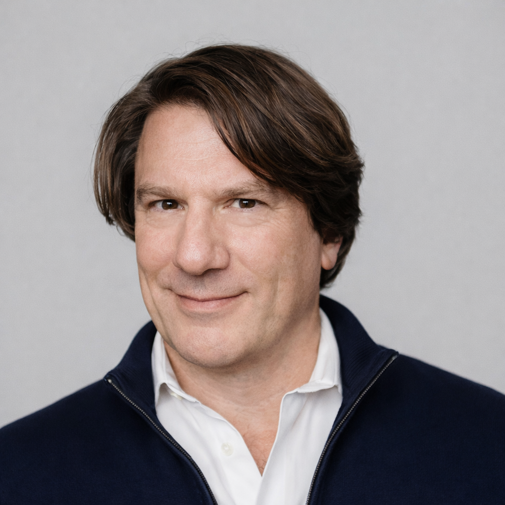 Black and white portrait of a man with dark hair, wearing a dark jacket and white shirt.