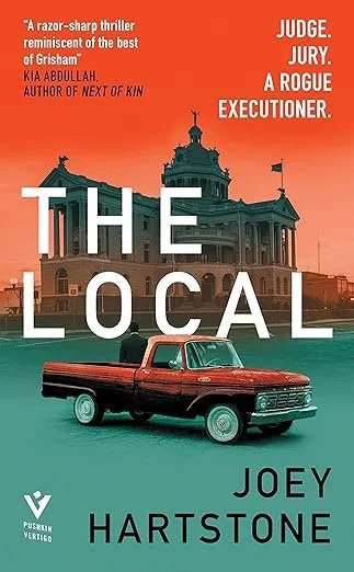 Cover of the book titled 'The Local' by Joey Hartstone featuring an illustration of a red pickup truck in front of an ornate government building during sunset. The cover includes quotes describing the book as a razor-sharp thriller and a rogue execut
