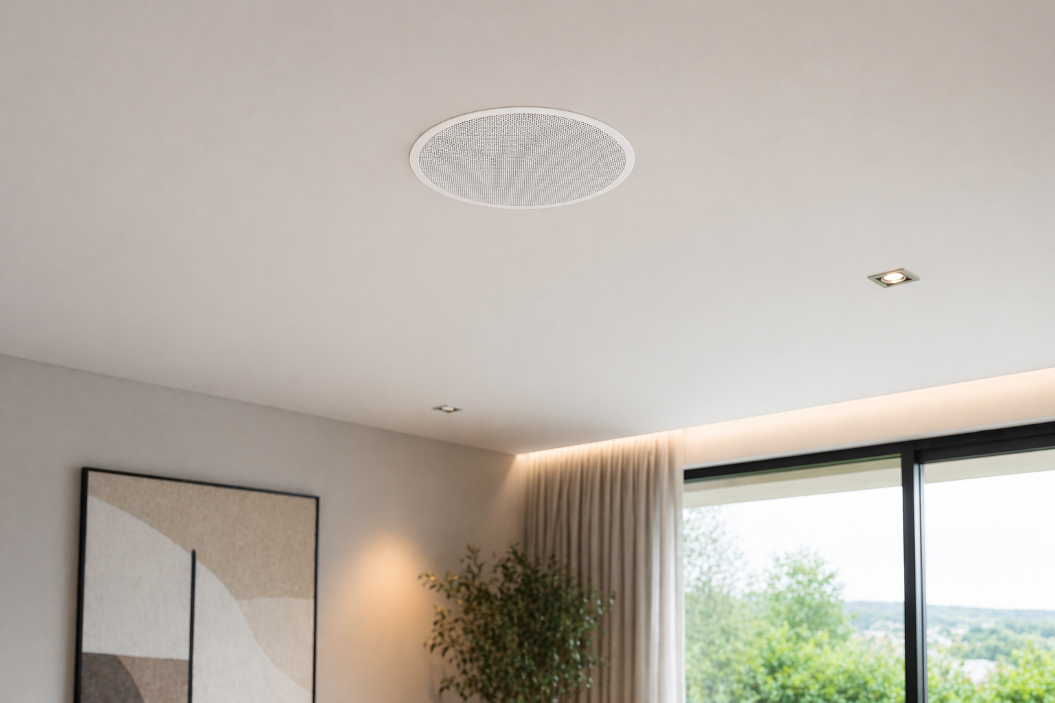 Modern living room ceiling with a central round speaker and two small recessed lights, large window with beige curtains, and a green potted plant in the corner.