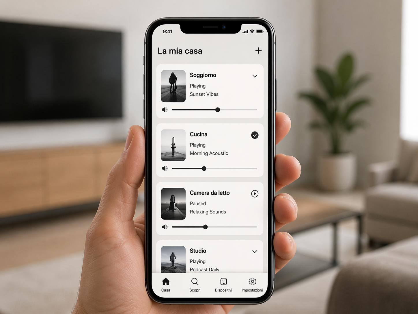 Hand holding smartphone displaying a home automation app with multiple music and sound settings, in a modern living room.