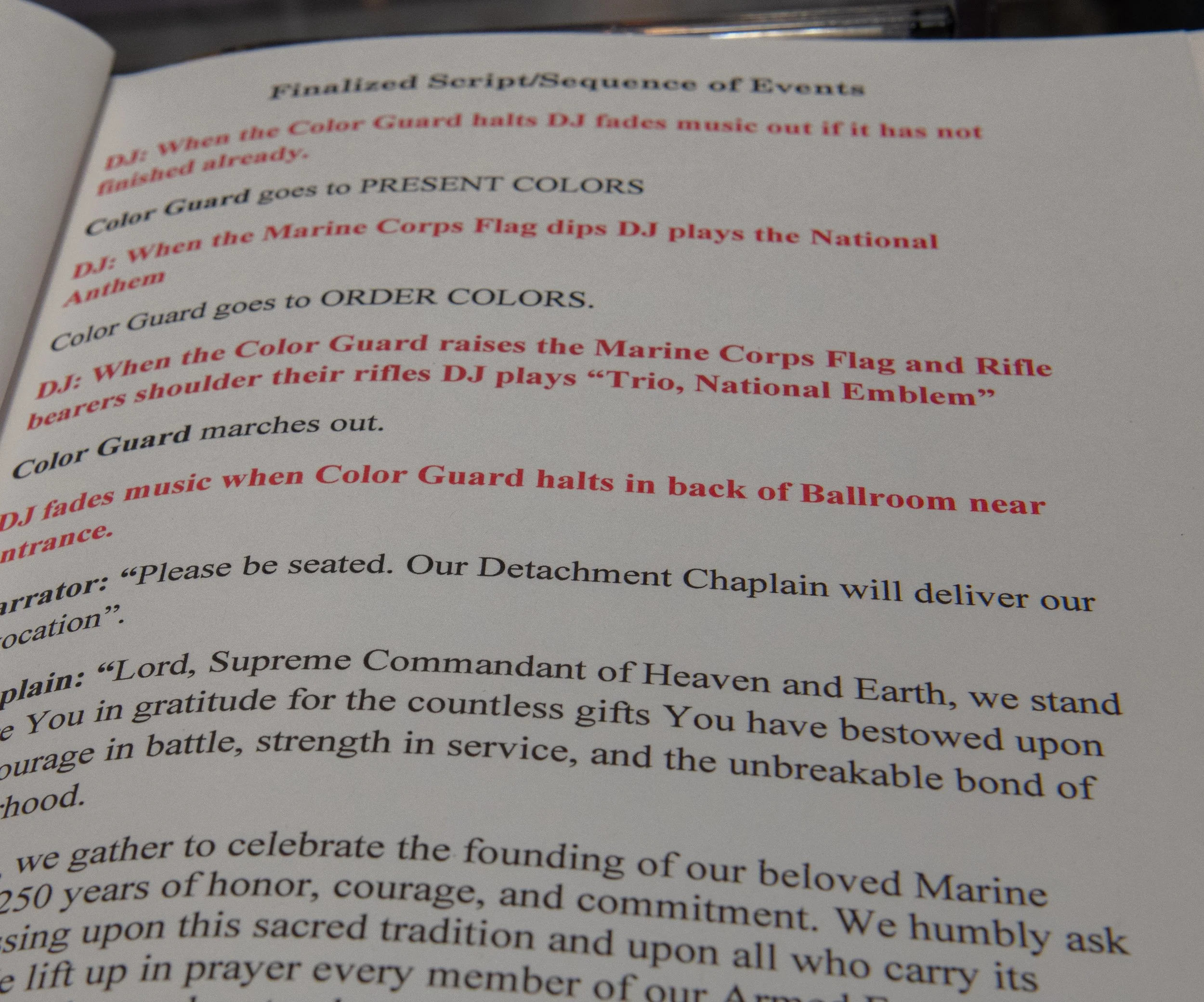 A printed script titled 'Finalized Script/Sequence of Events' with instructions and dialogue related to a Marine Corps and Navy event, including mentions of a Color Guard, DJ, and ceremonial procedures.