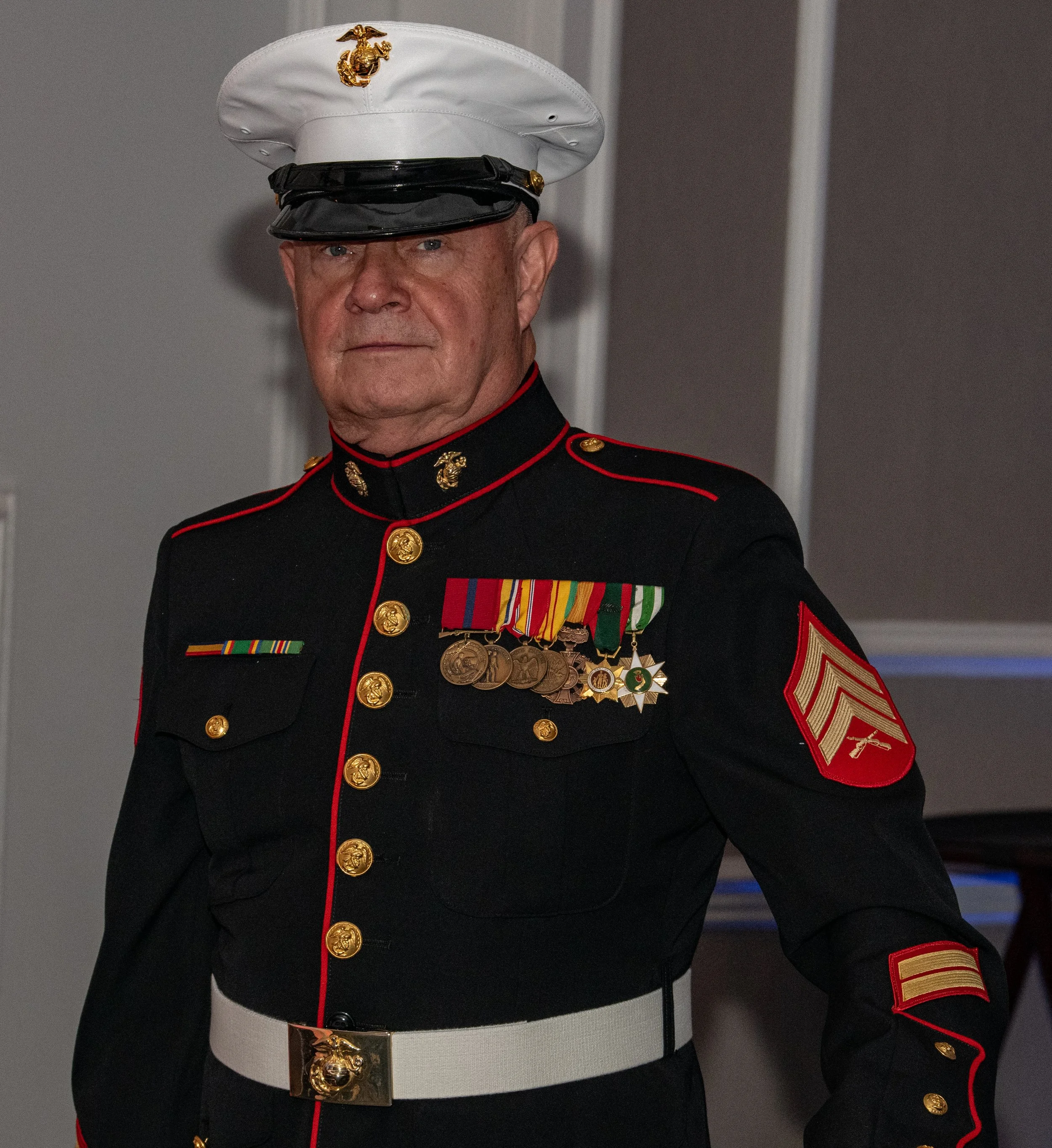 A man in a United States Marine Corps dress uniform with medals and rank insignia.
