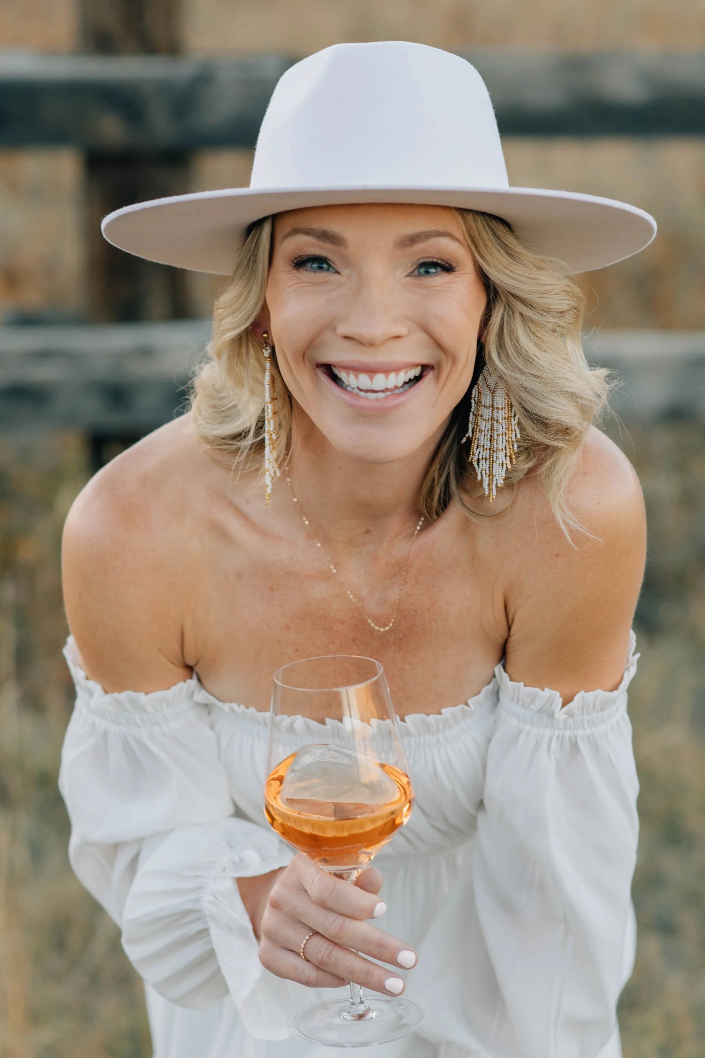 Wine tasting host laughing while holding a glass of rosé