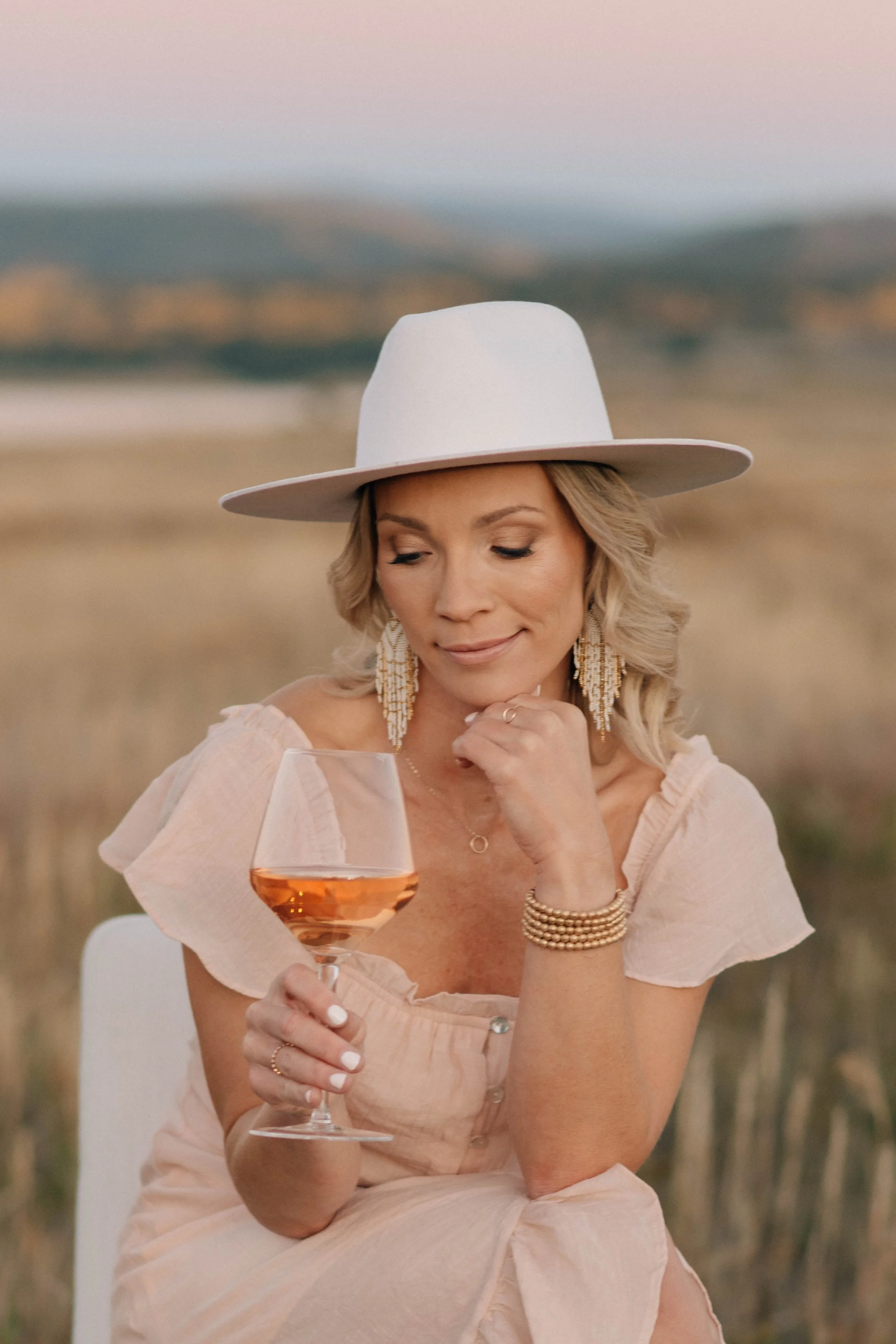 Wine tasting host holding a glass of rosé in a quiet moment
