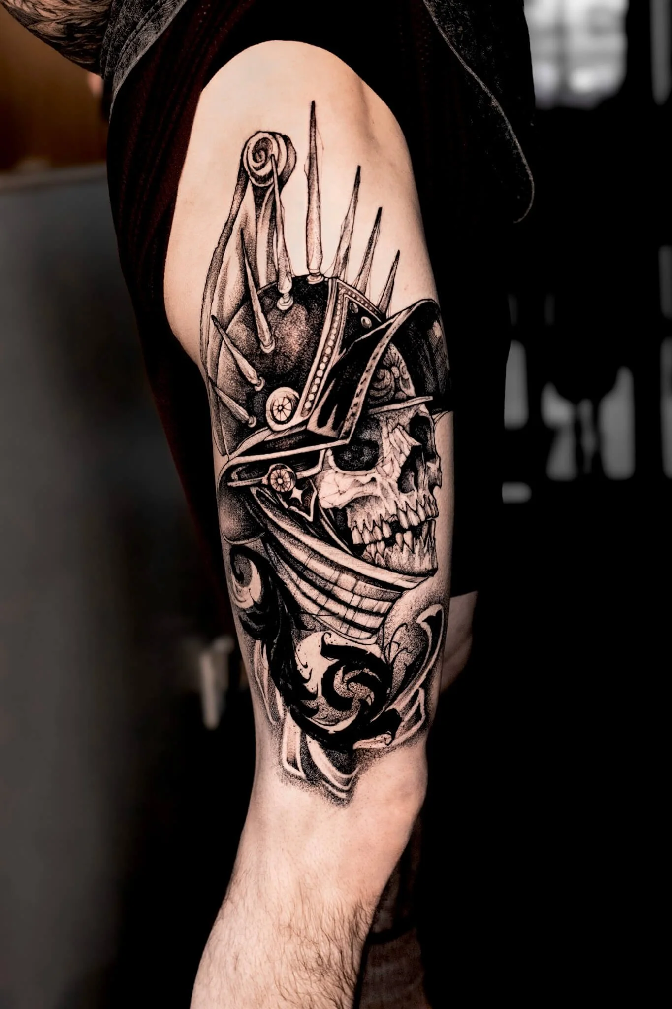 Black-and-gray skull warrior arm tattoo.