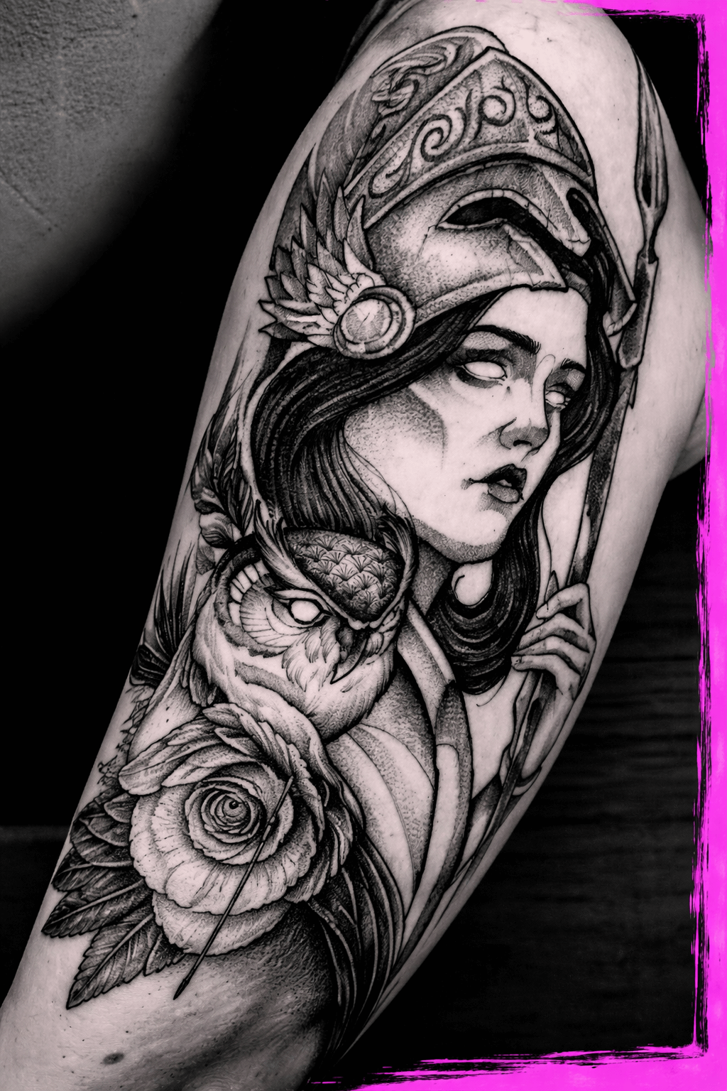 Black and gray tattoo of a woman with long hair wearing a helmet with ornate designs, holding a bow, with a bird and a rose near her shoulder.