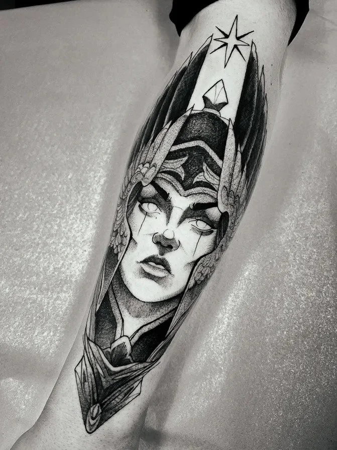 Black-and-gray Valkyrie portrait forearm tattoo.