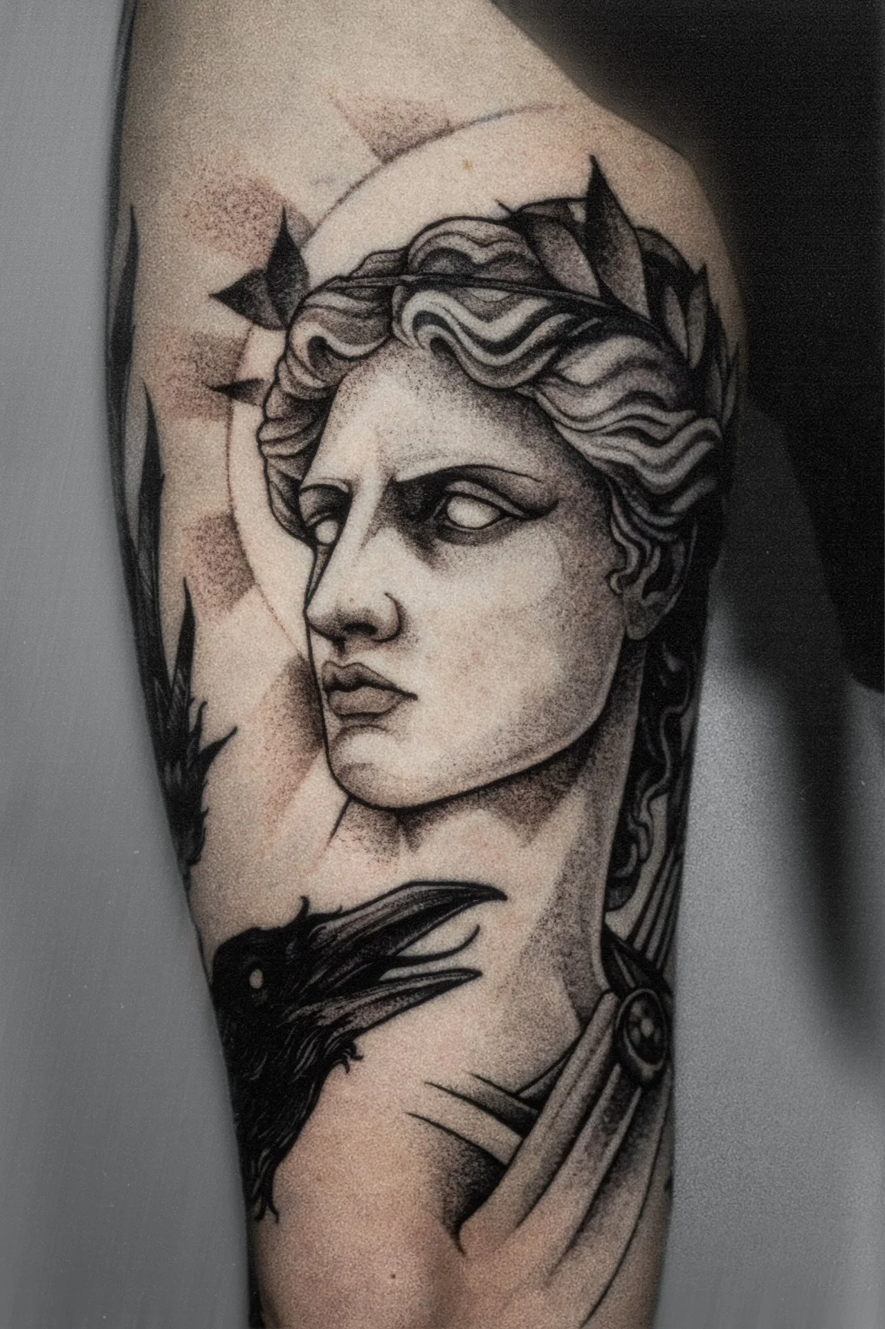 Black-and-gray classical statue portrait tattoo on leg.