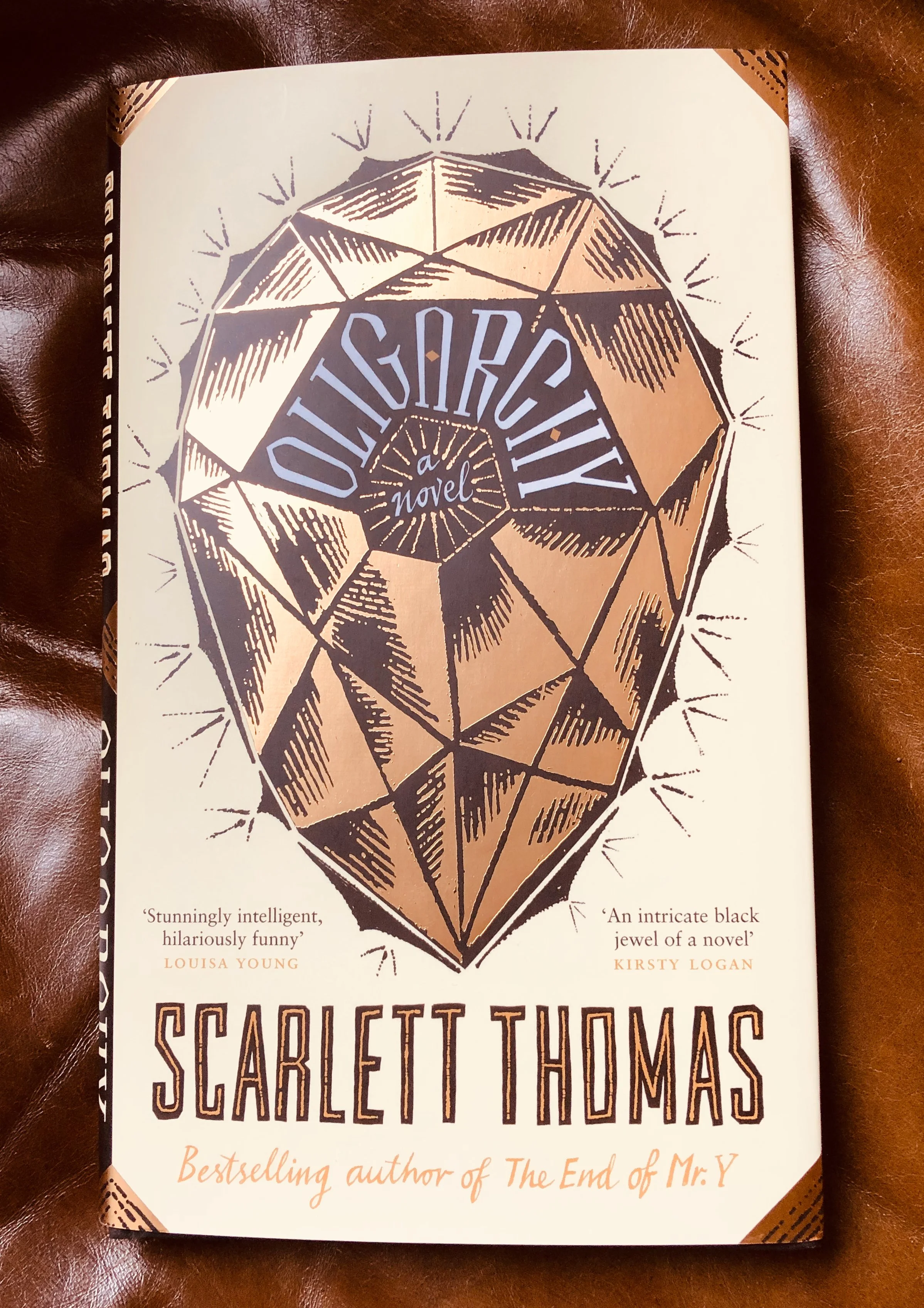 Book cover of 'A Glittering Diamond' by Scarlett Thomas with a large illustration of a faceted diamond on a cream background.